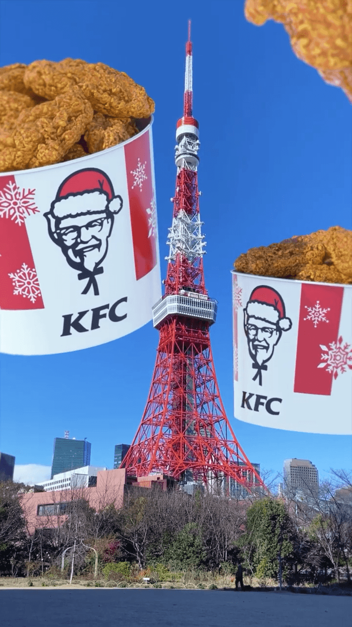 도쿄타워 주변에 크리스마스 디자인의 거대한 KFC 치킨 버킷이 떠 있는 FOOH 장면