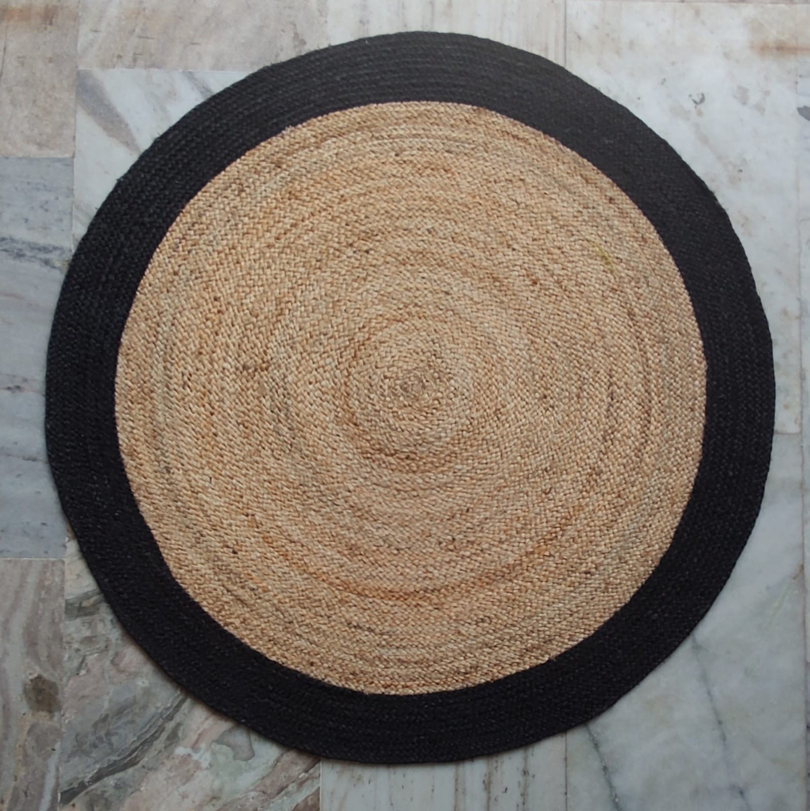Handwoven round jute rug with black contrast border