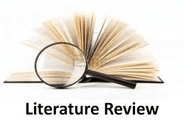 High school student writing a literature review at a desk surrounded by academic journal articles and research notes