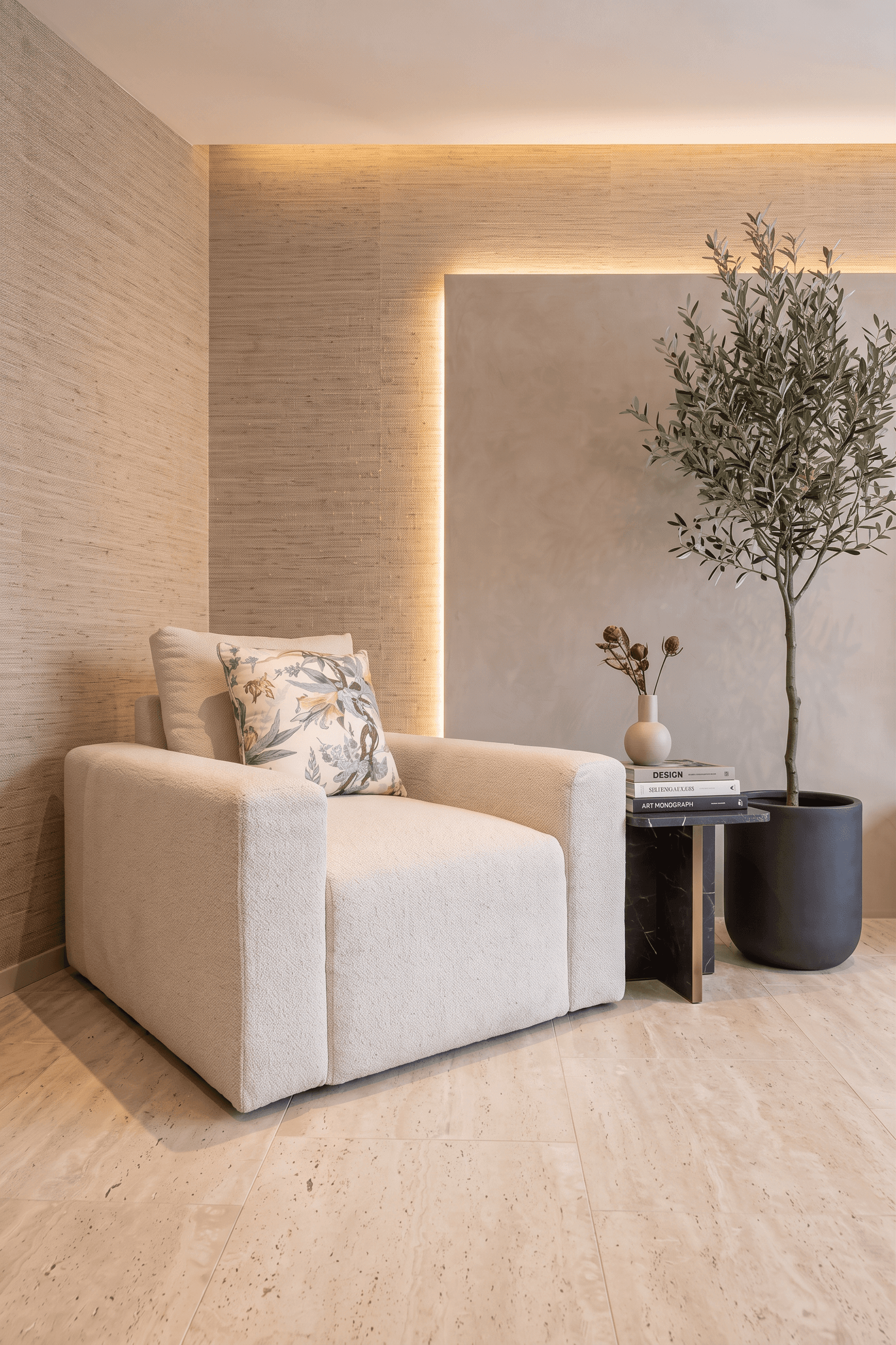 A cream boucle armchair against a grass-cloth wall beside an olive tree. The room was generated with AI.