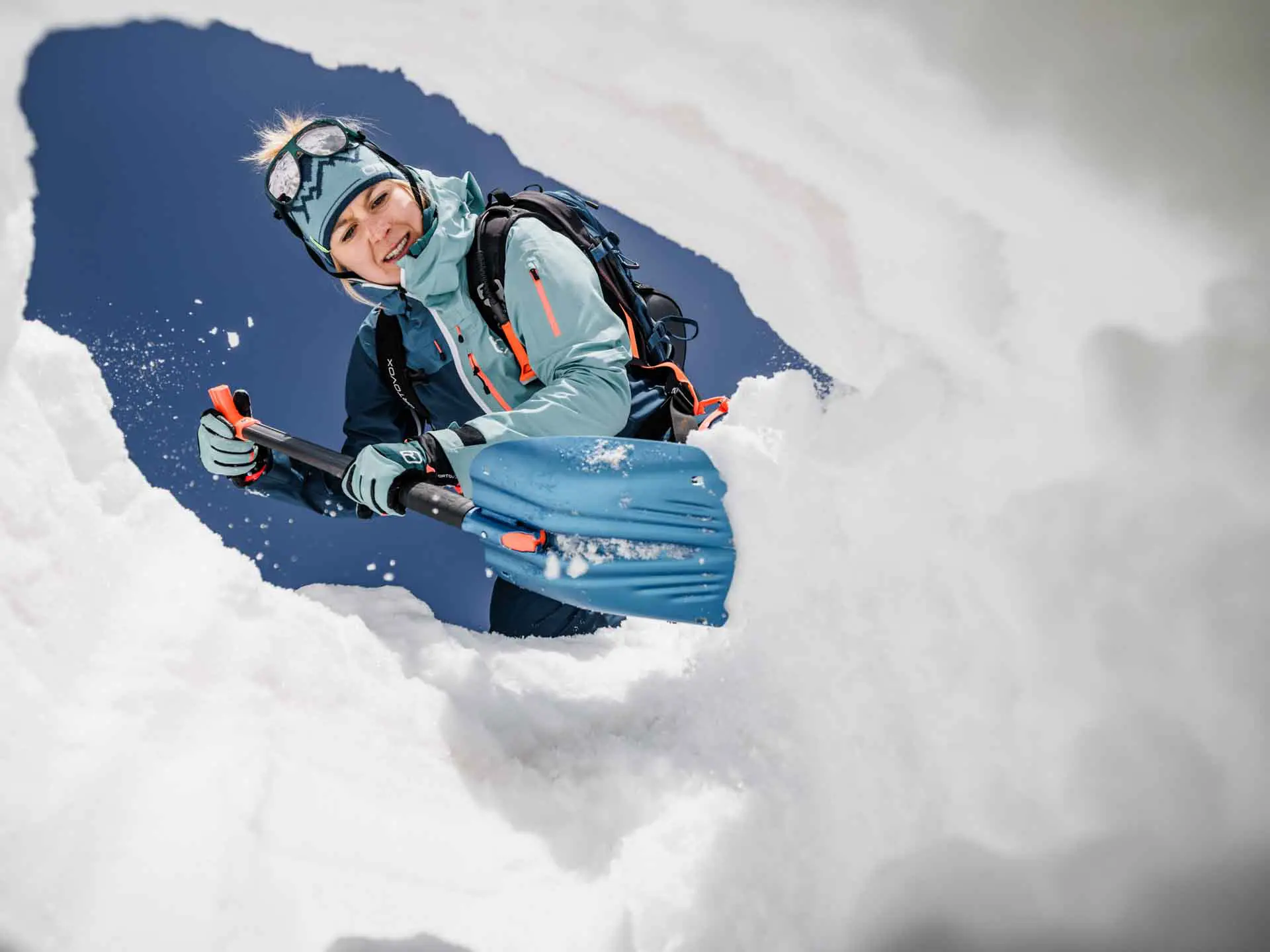 Participant practicing avalanche rescue excavation with a shovel during a backcountry safety training