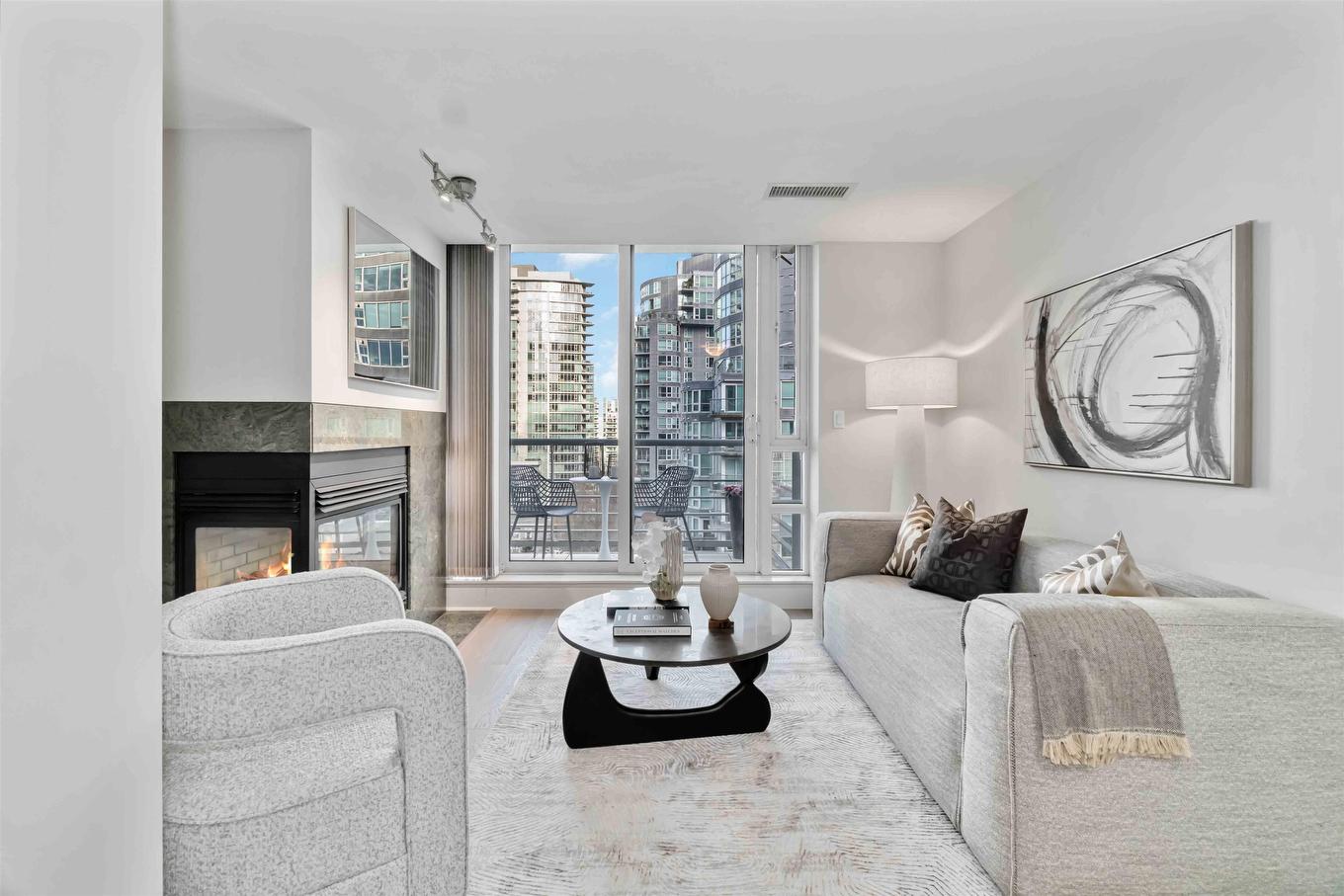 Modern kitchen with white cabinetry, sleek countertops, and large windows showcasing a city view.