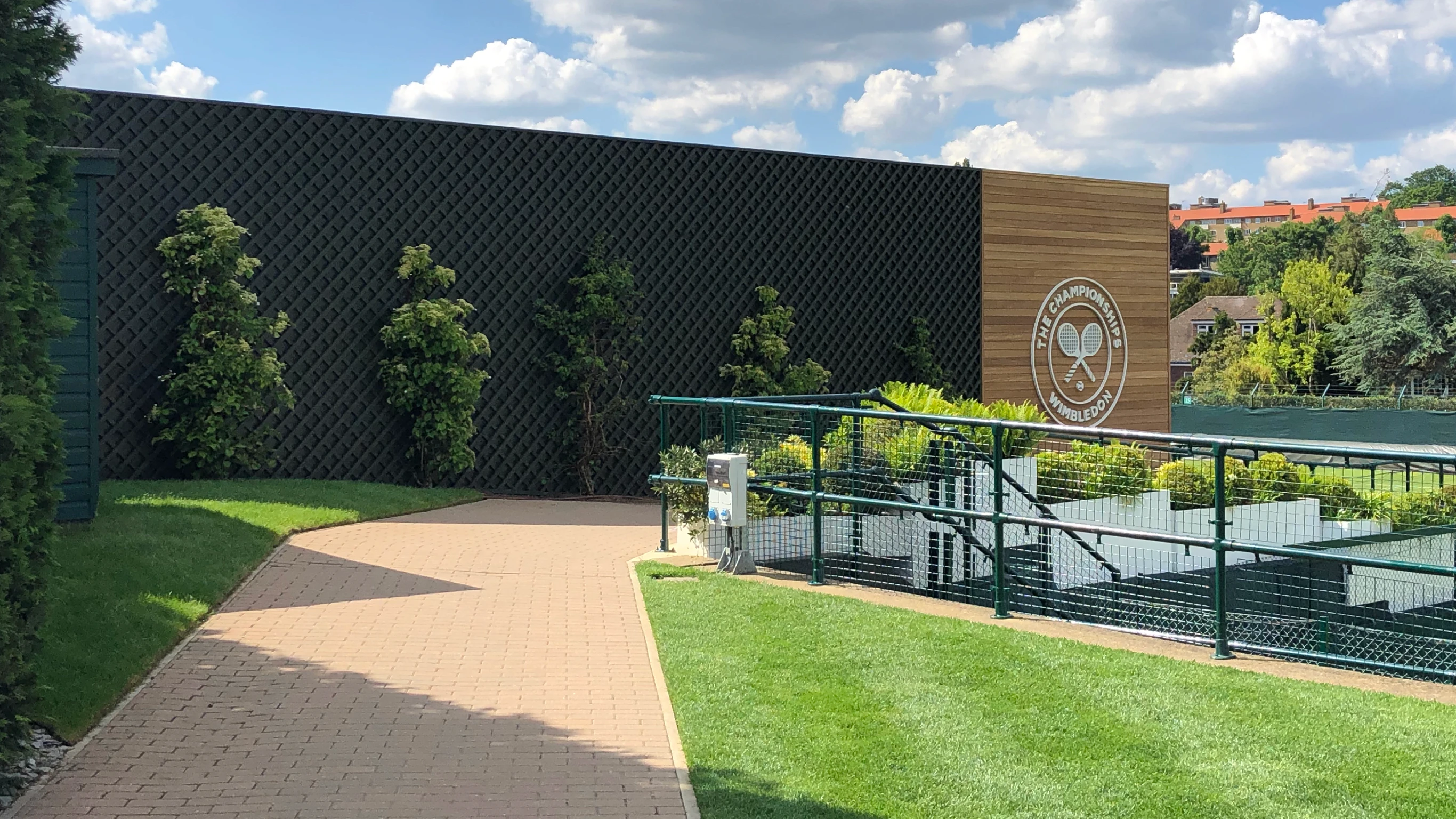 Wimbledon Tennis Club landscaped gardens with brand logo affixed to wooden slatted details