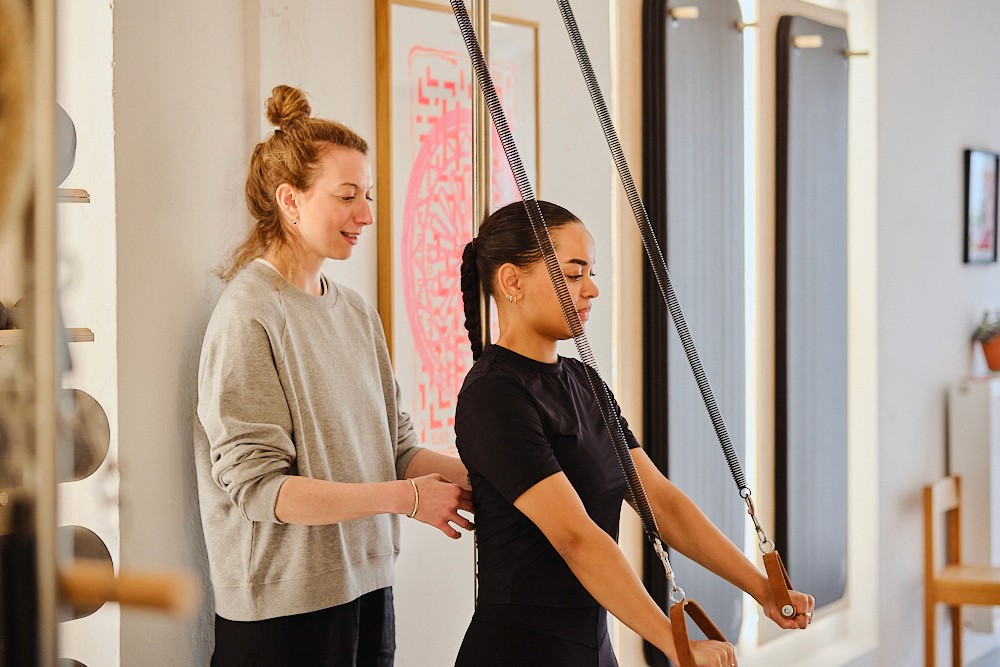 Pilates instruktør guider kvinde