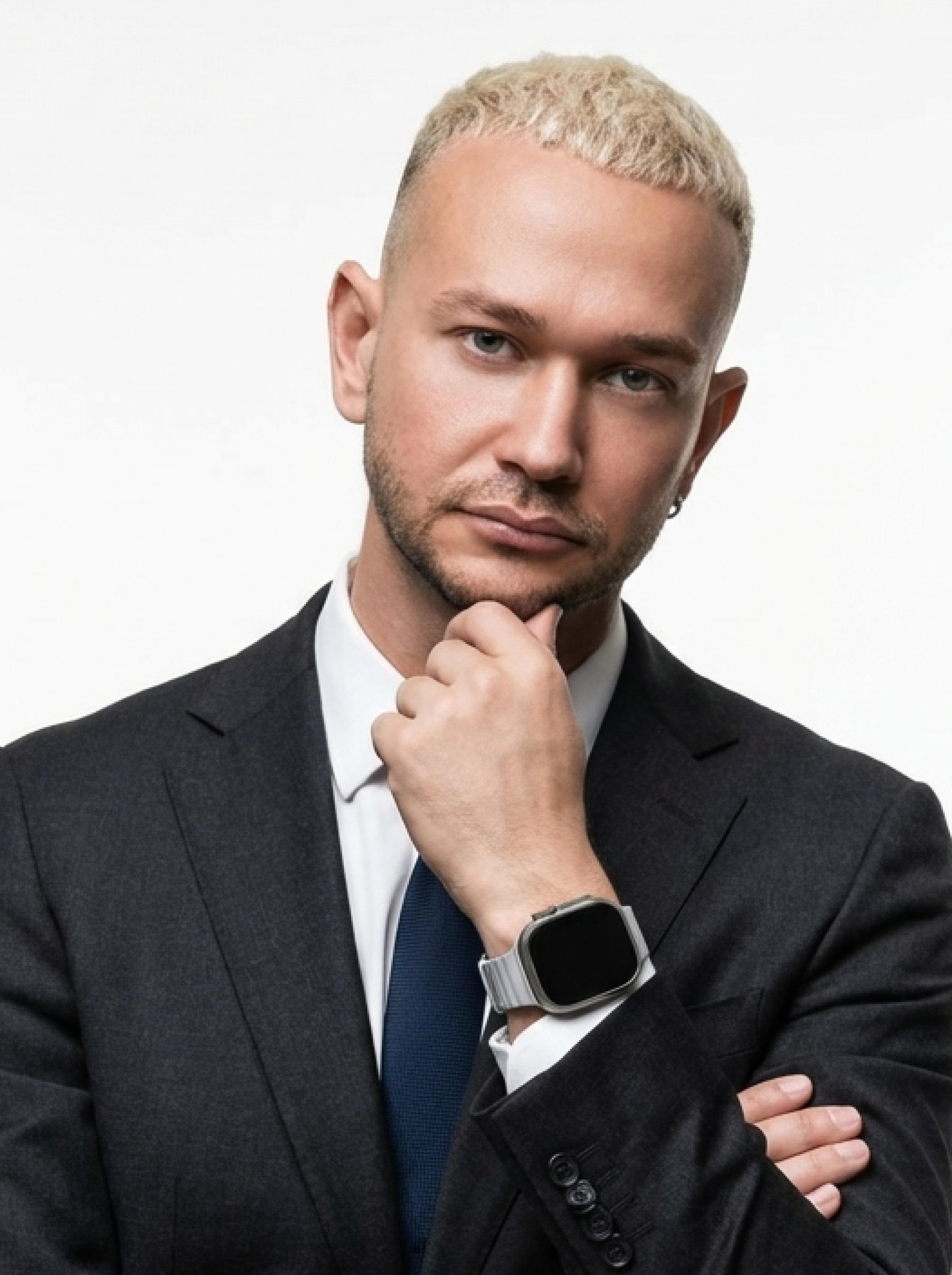 Portrait of a young man with short hair, wearing a dark t-shirt, against a plain background.