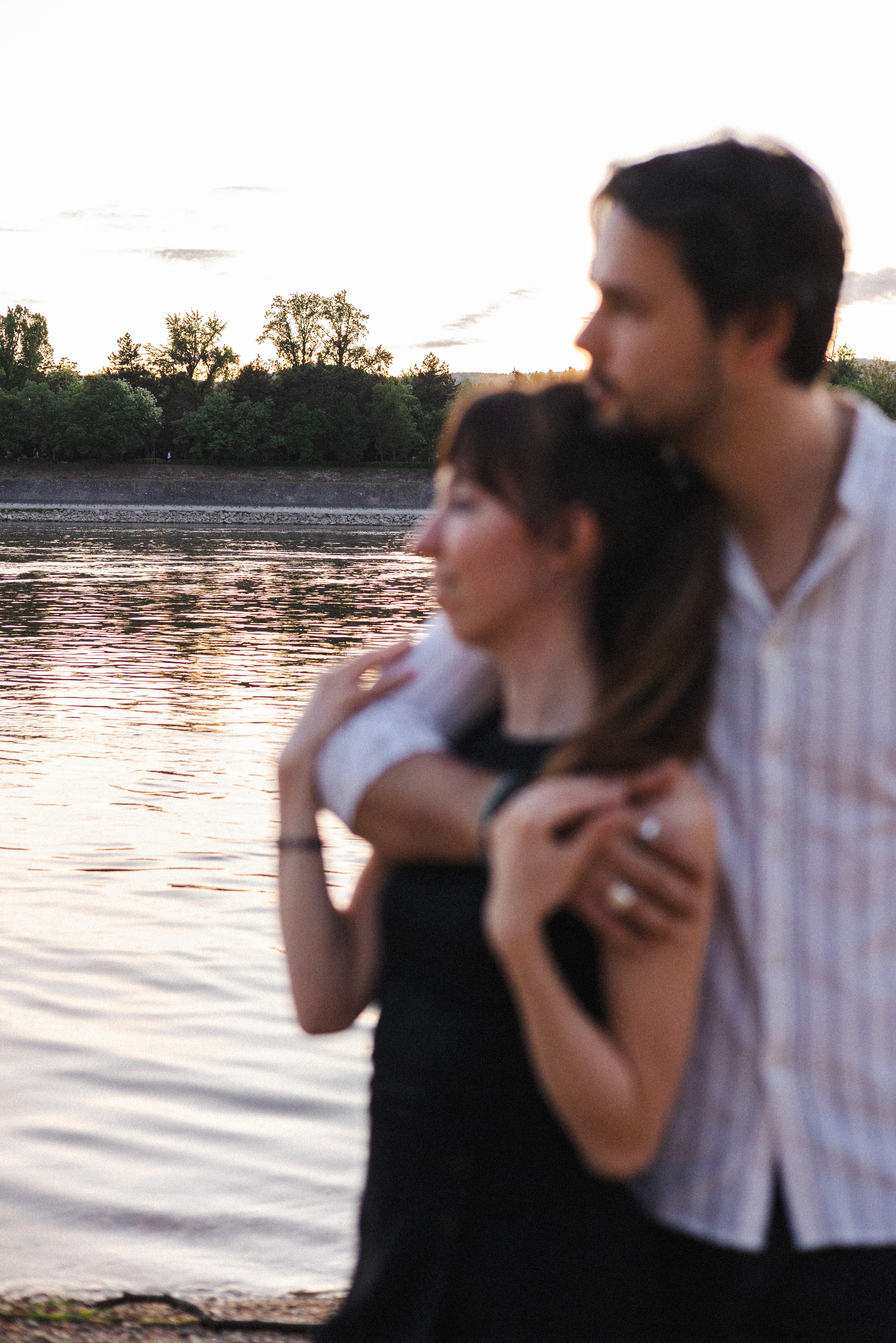 Man in motion during a yoga session in a light-filled modern room with large windows, wood floors, greenery visible outside