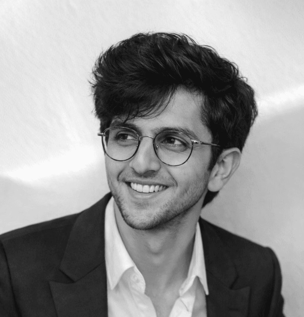Person sitting in a modern office in front of a wall covered with notes and sketches.