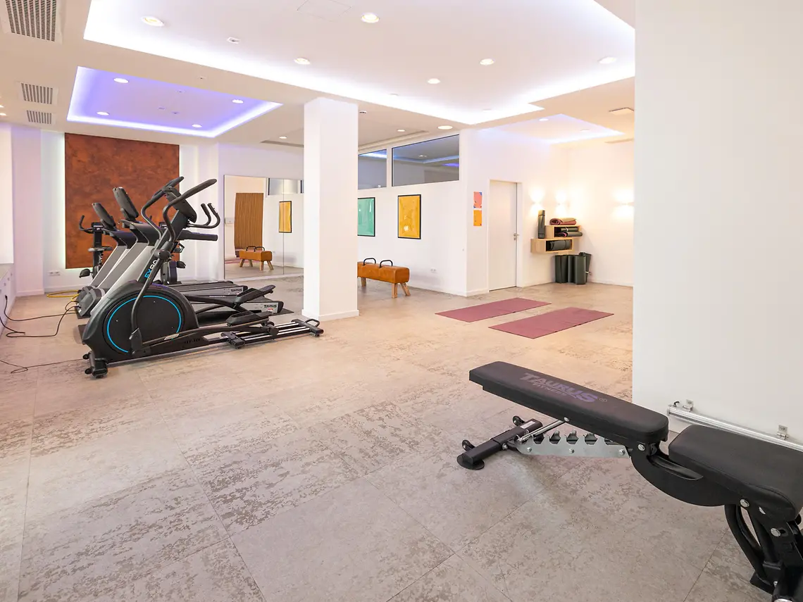 Student gym in Münster accommodation with cardio machines, workout bench and yoga exercise space