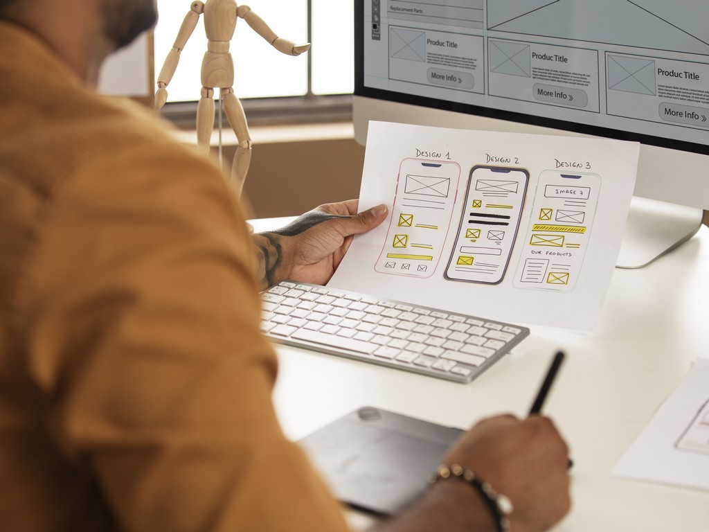 Profissional de UX design usa mesa digital para criar wireframe de app para celular
