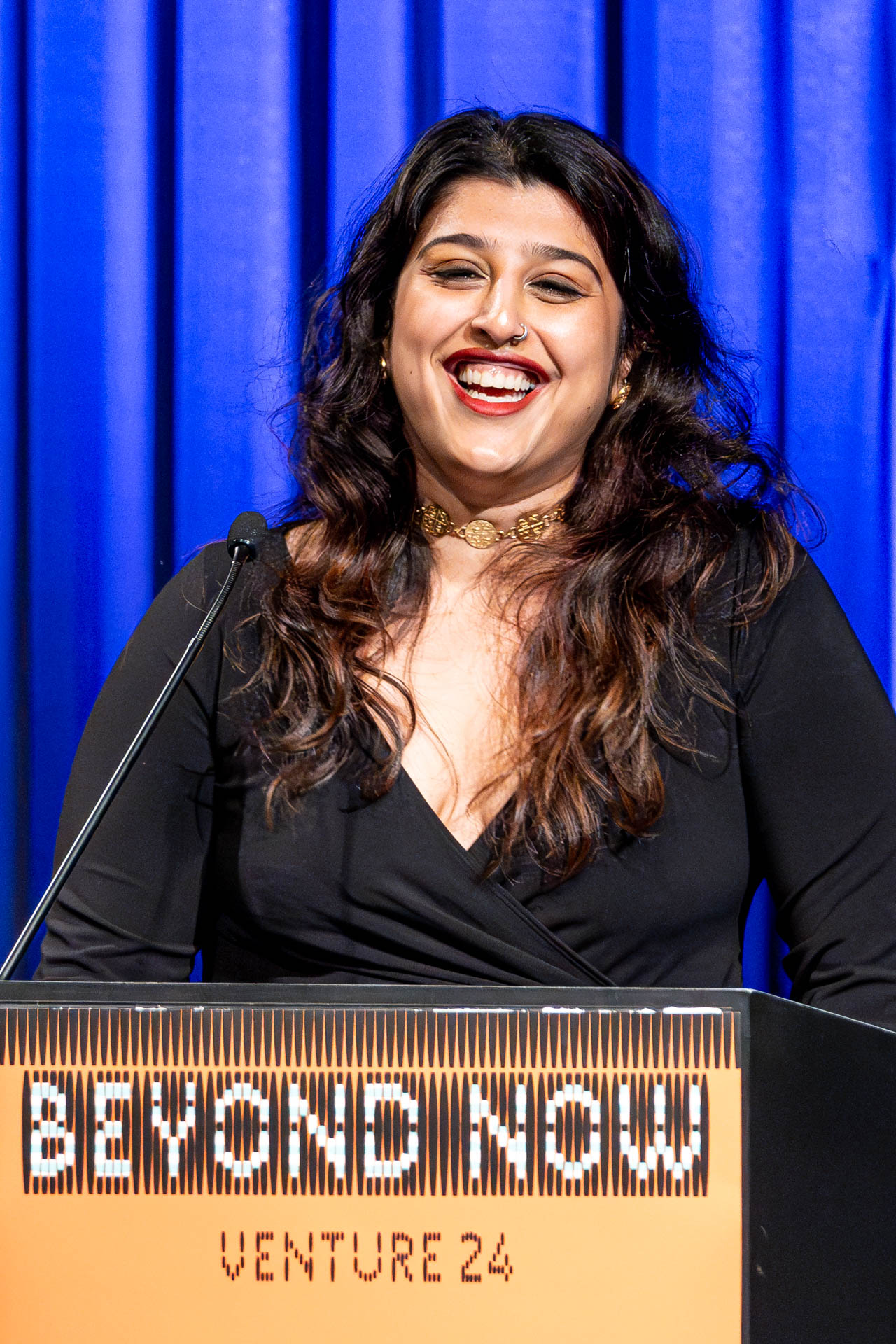 a student at a podium presenting a project in a Theatre