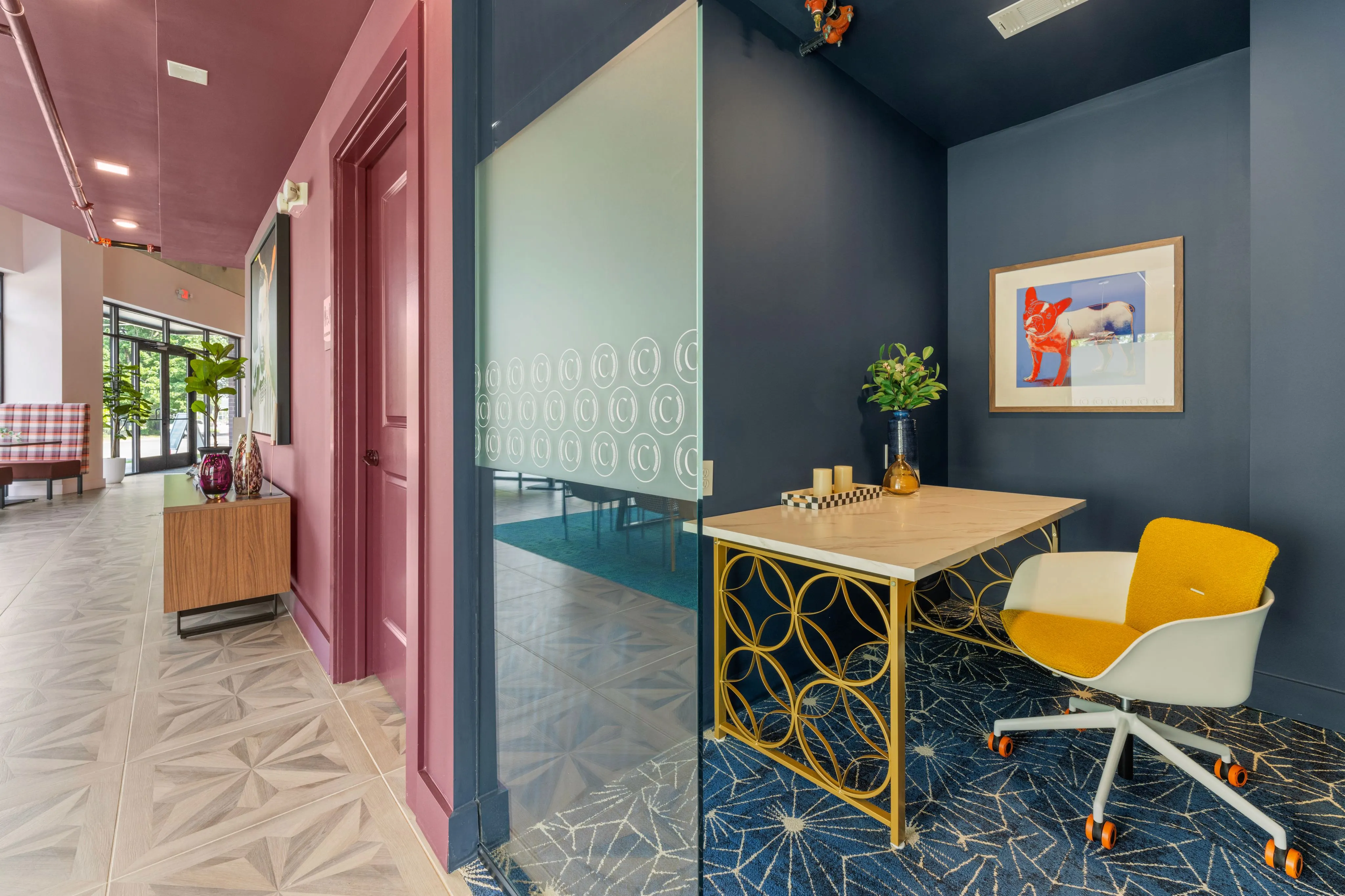 A resident lounge and co-working space featuring a vibrant pink and blue wall design.