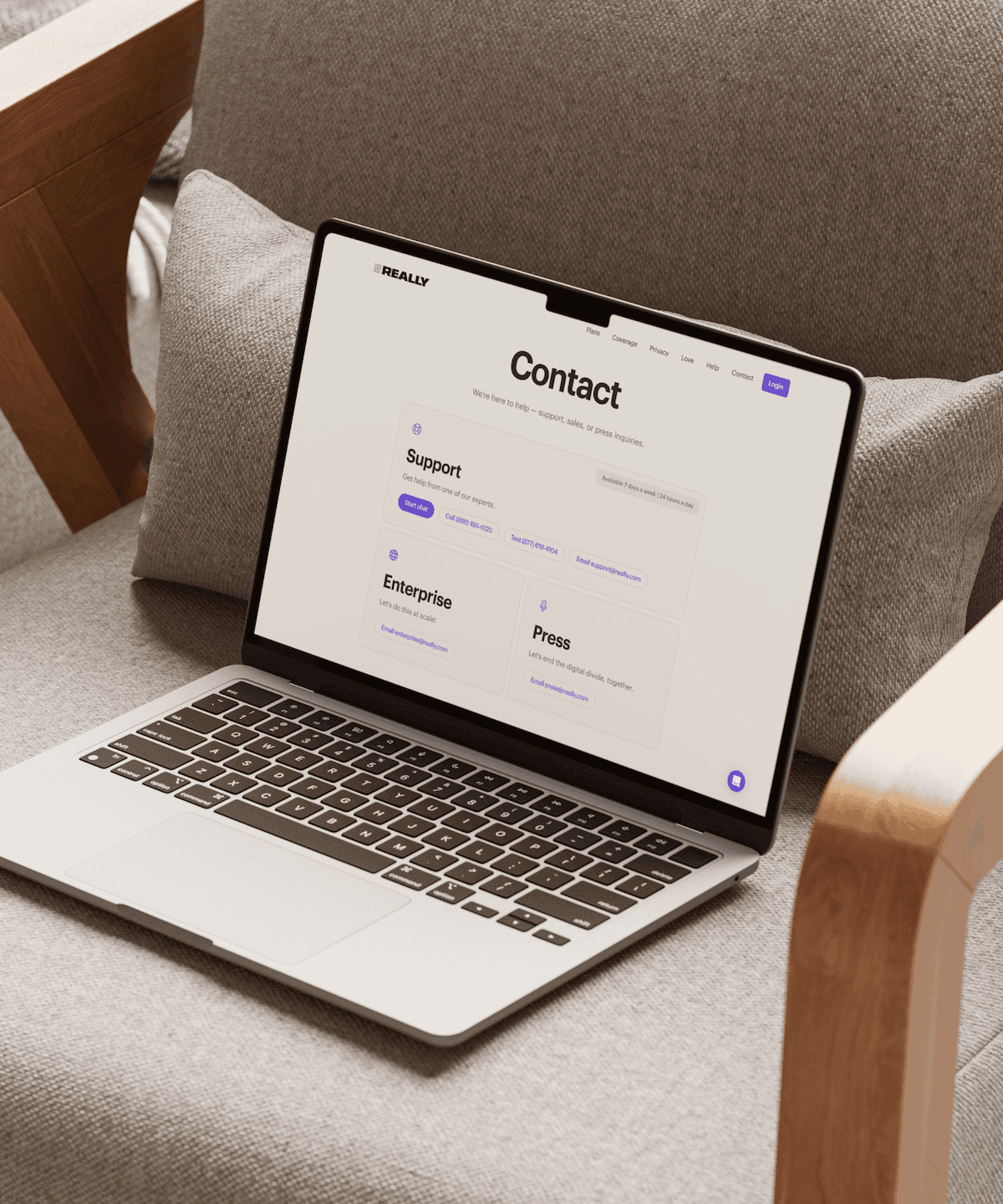 MacBook on armchair displaying Really contact page — Really case study by Boldway Studio