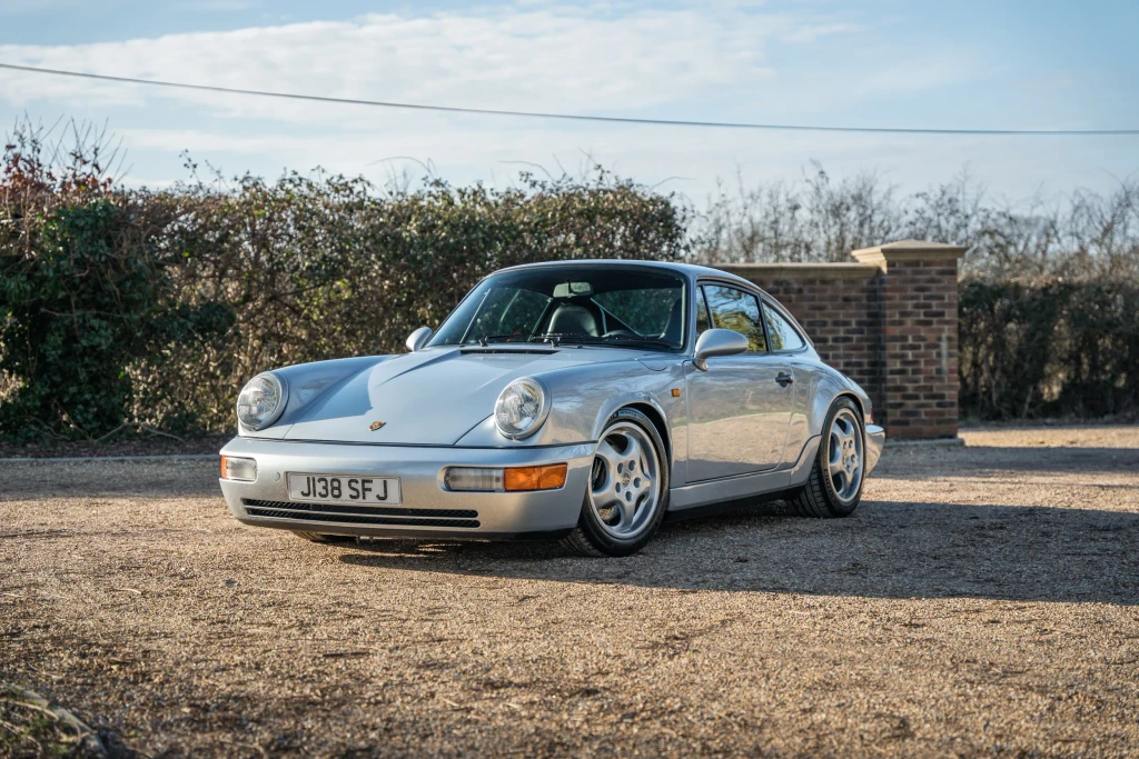 silver porsche on gravel driveway