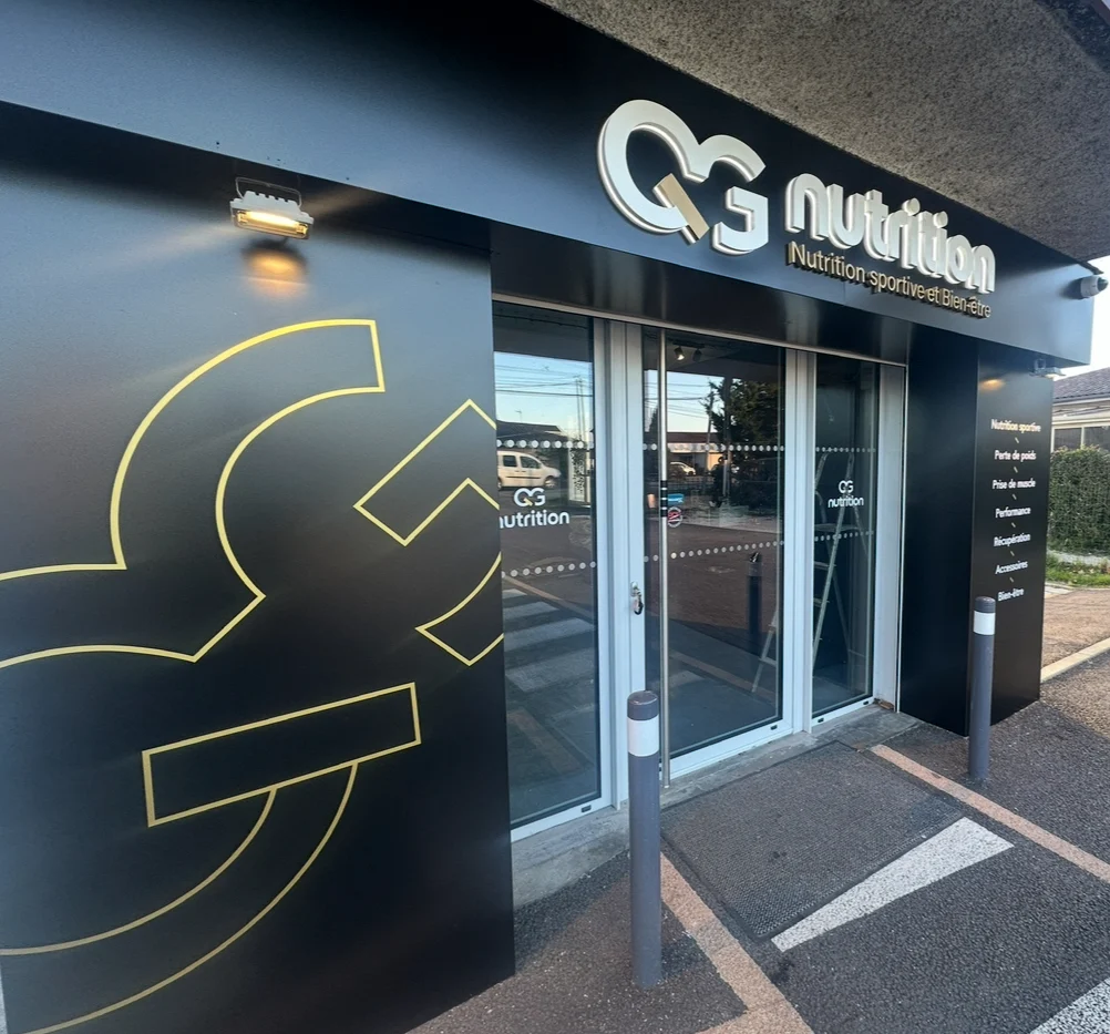 Enseigne publicitaire sur commerce QG Nutrition, logo et horaires d'ouvertures