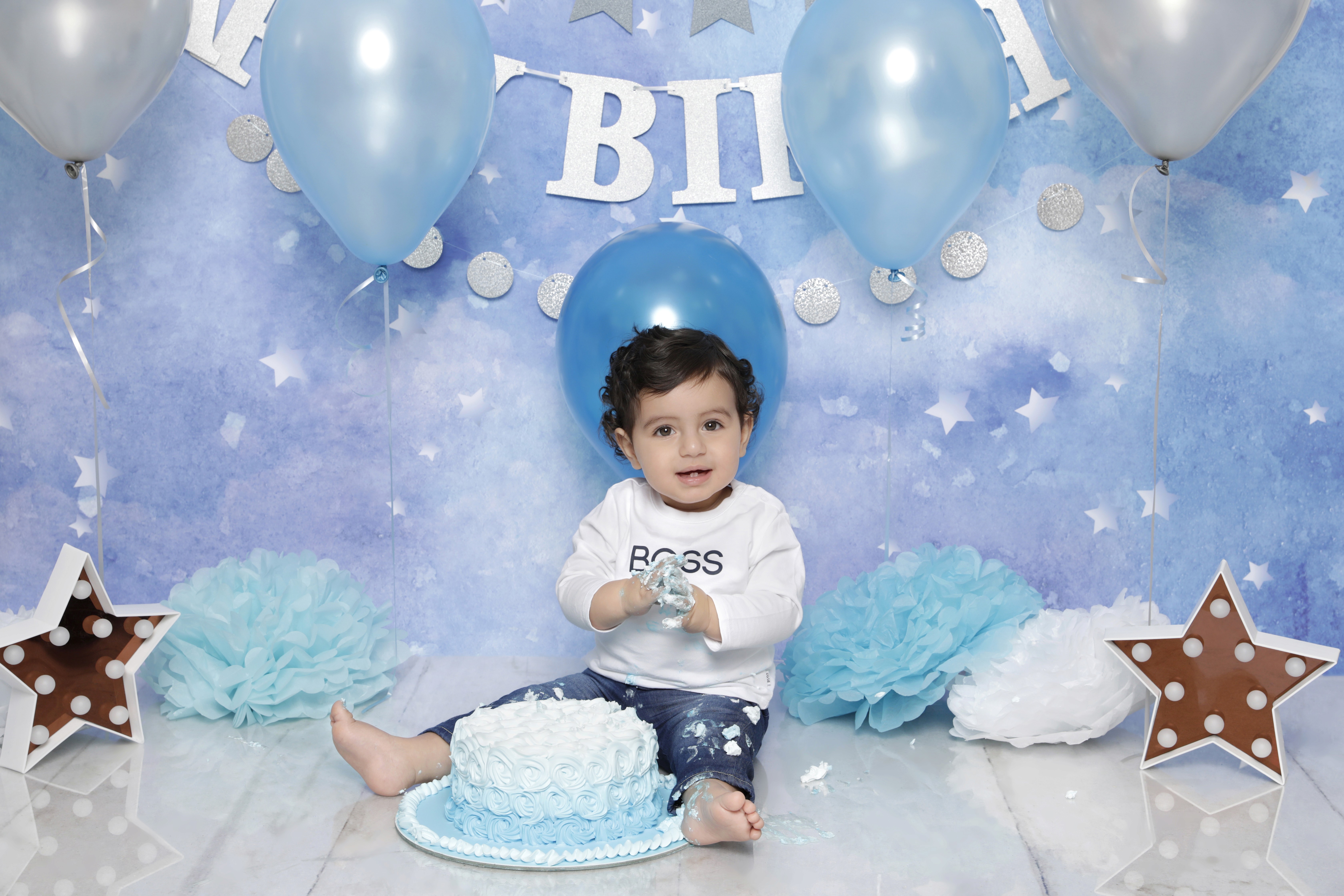 Baby boy enjoying his first birthday cake smash