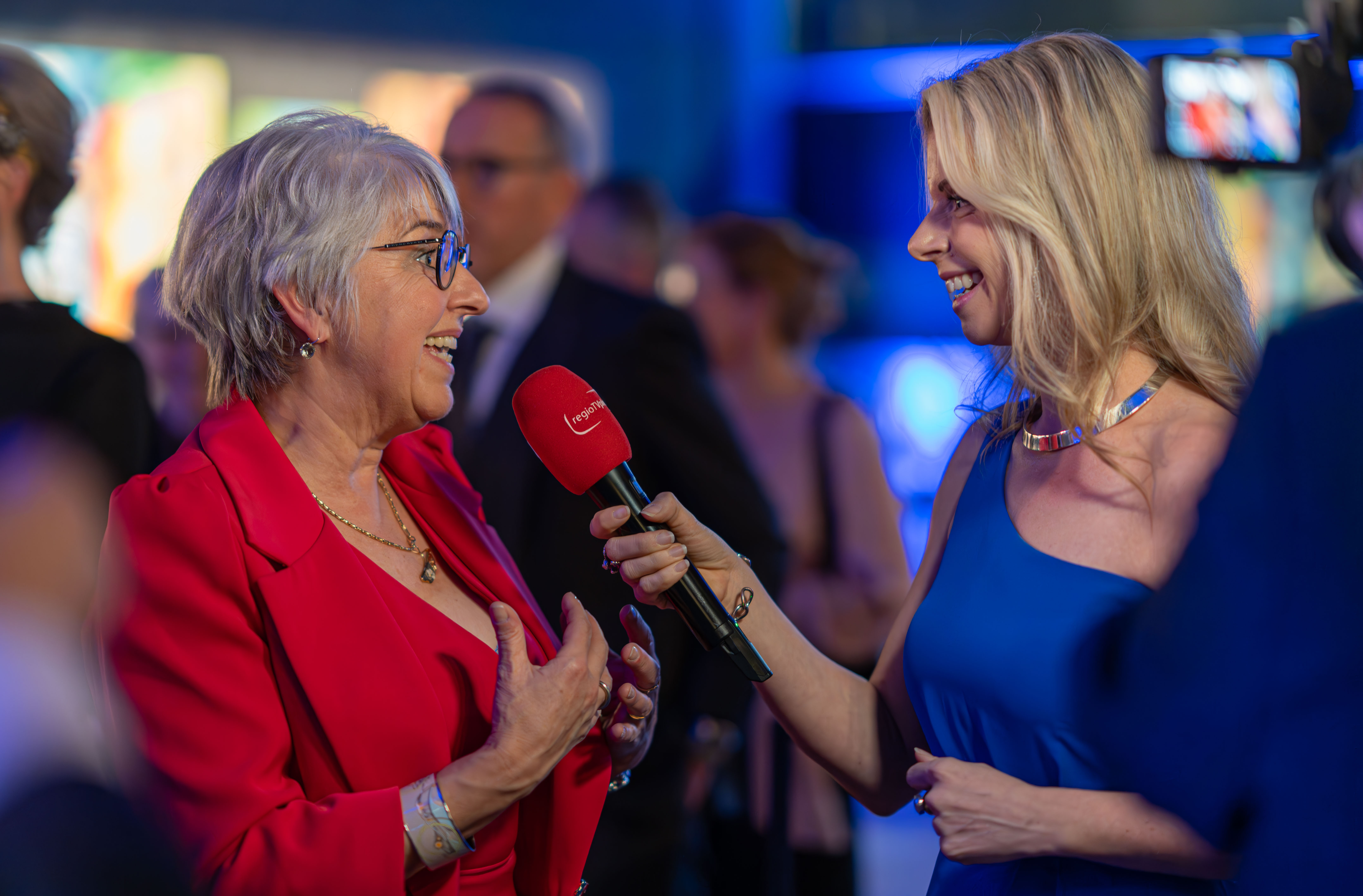 Moderatorin Désirée Lehmann interviewt die Bundesrätin Elisabeth Baume-Schneider und hält dabei ein Mikrophon.