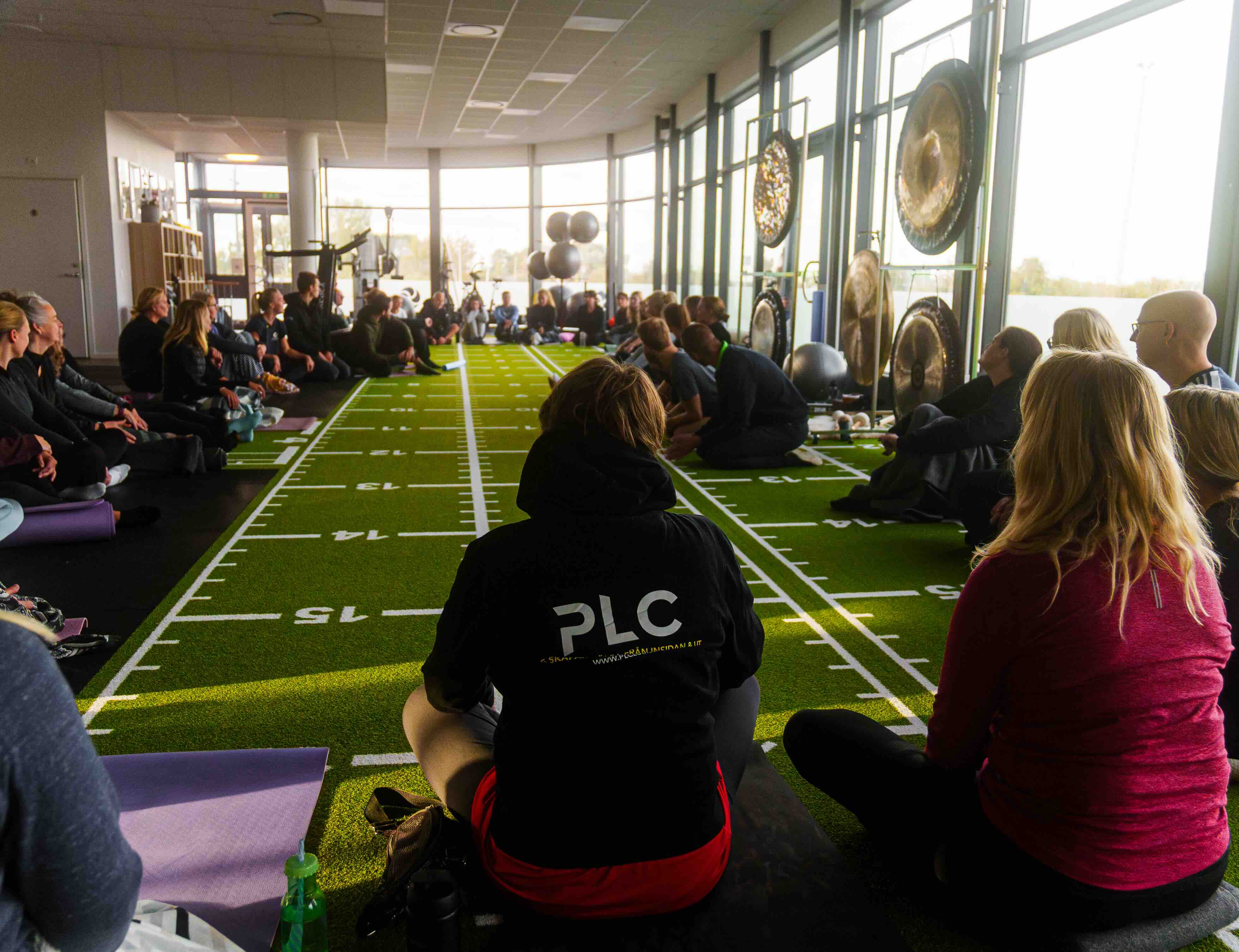 A men's volleyball team wearing blue jerseys gathered in a tight huddle on the court.