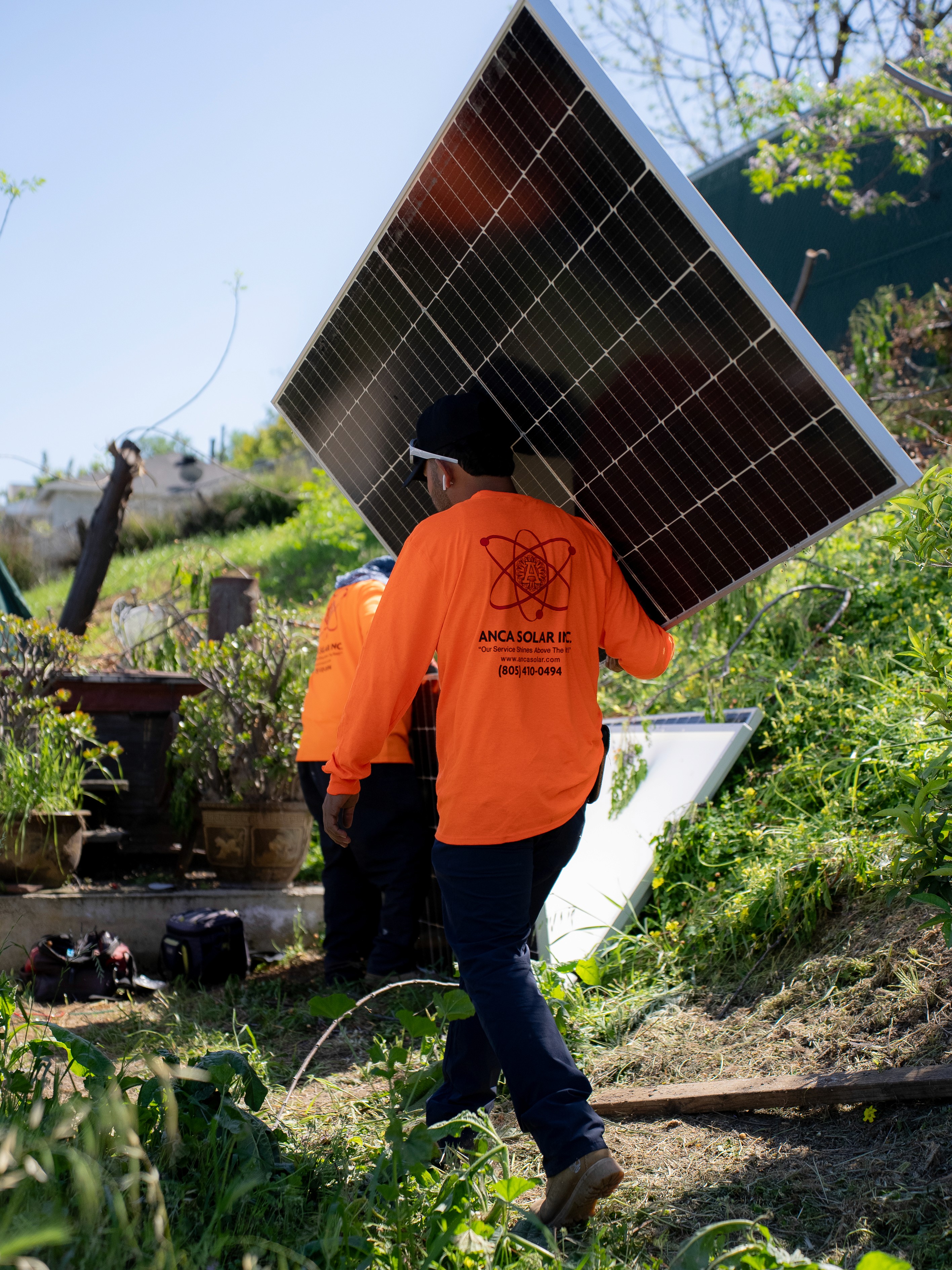 Anca Solar Employees With a Solar Panel
