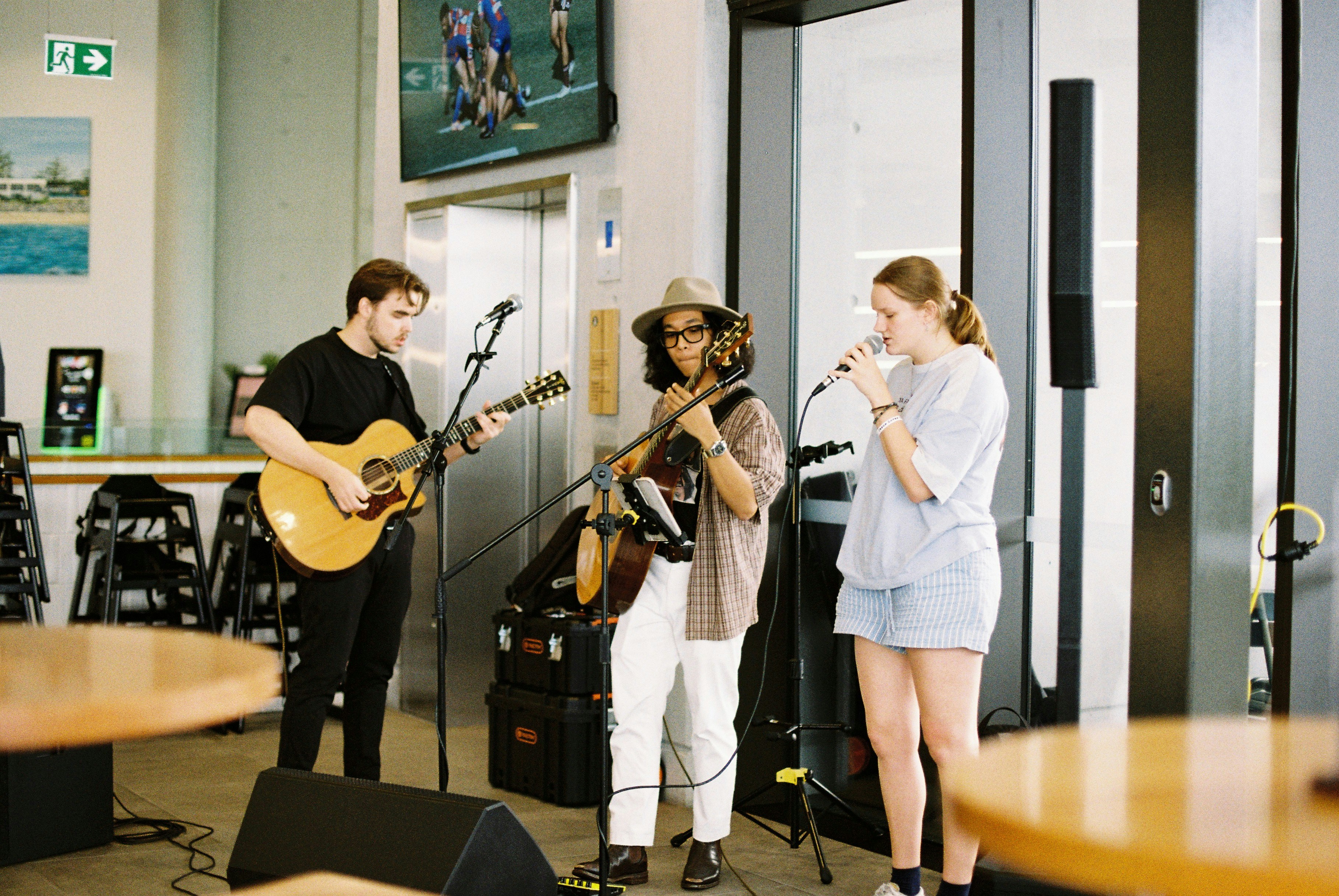 Three musicians perform live music indoors.
