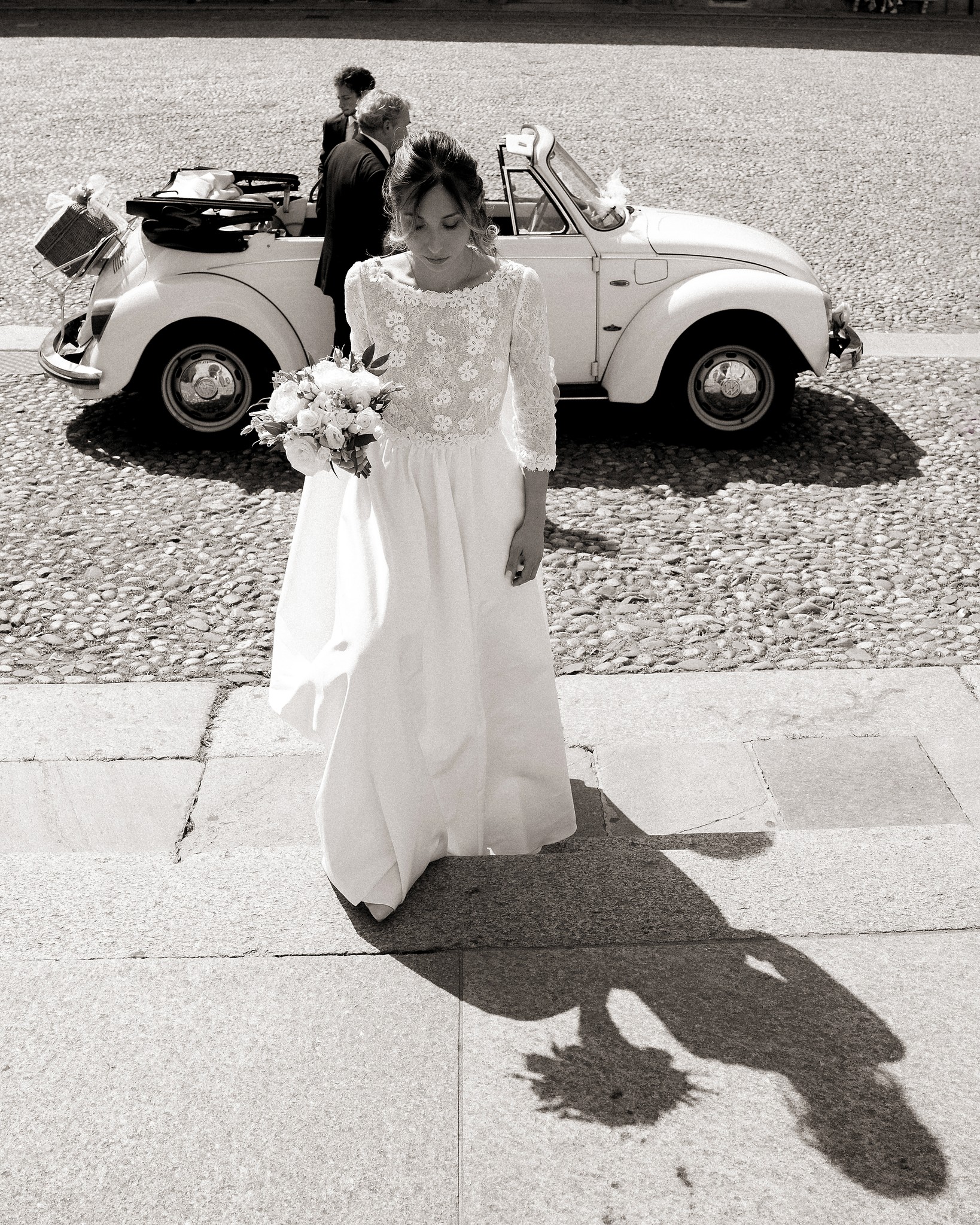 Sposa in abito bianco davanti al Maggiolino vintage a Villa Peroni Riva, reportage matrimoniale in bianco e nero