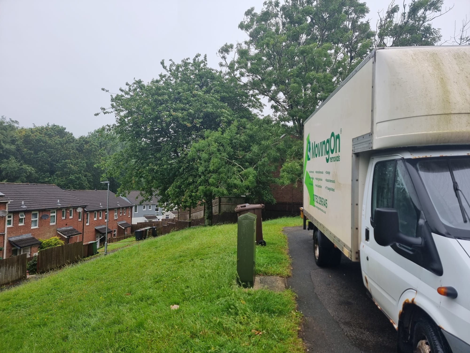 Moving On Removals crew navigating a long, steep pedestrian walkway to deliver furniture to a house in Estover, Plymouth.