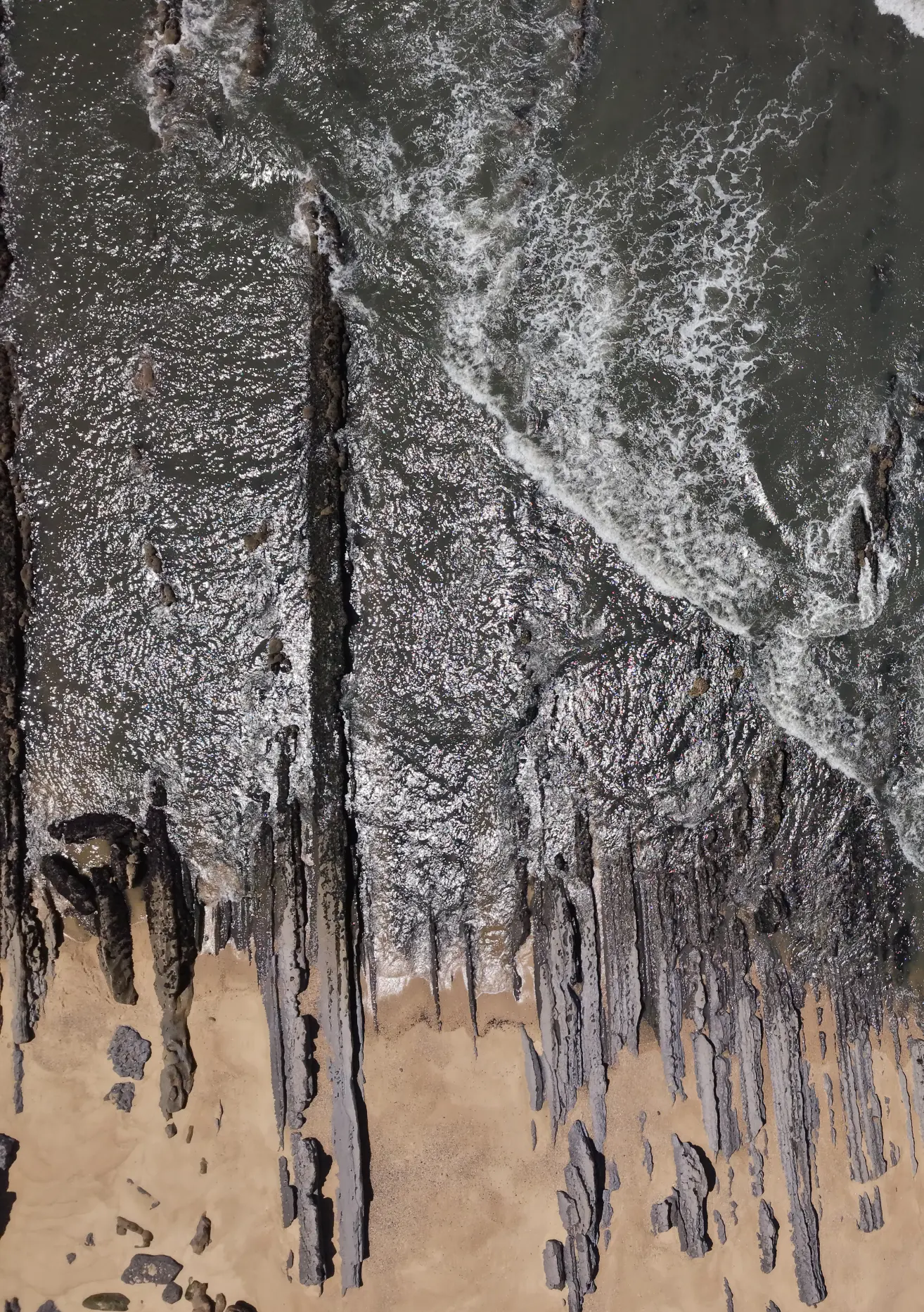 top view of ocean, rock and sand