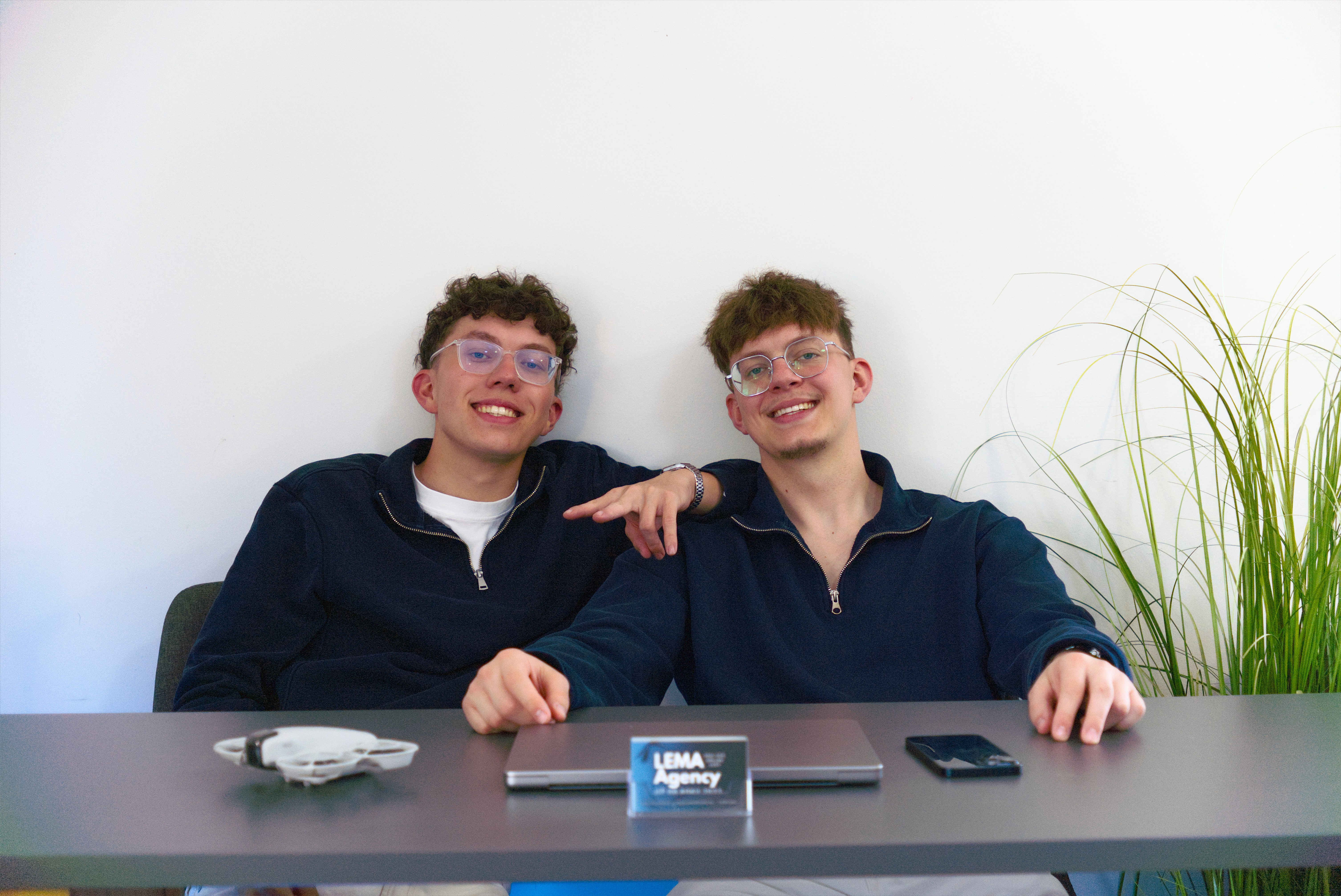 Woman with glasses working focused on laptop at wooden desk