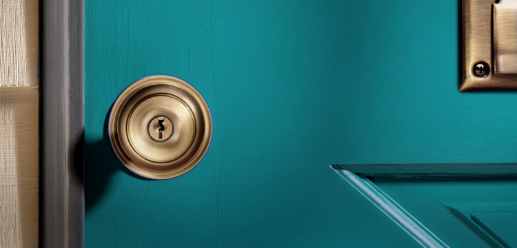 Front view of a golden doorknob on a turquoise wooden door, showcasing elegant craftsmanship.