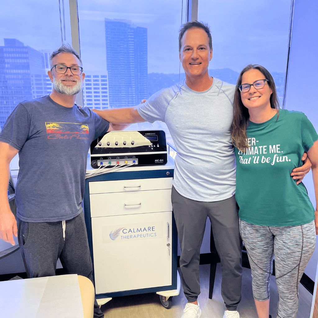 Featured video showing a female patient in a green shirt with text 'underestimate me, that'll be fun, a man with a blue shirt and Dr. Damon Orlando next to a Calmare Scrambler Therapy device