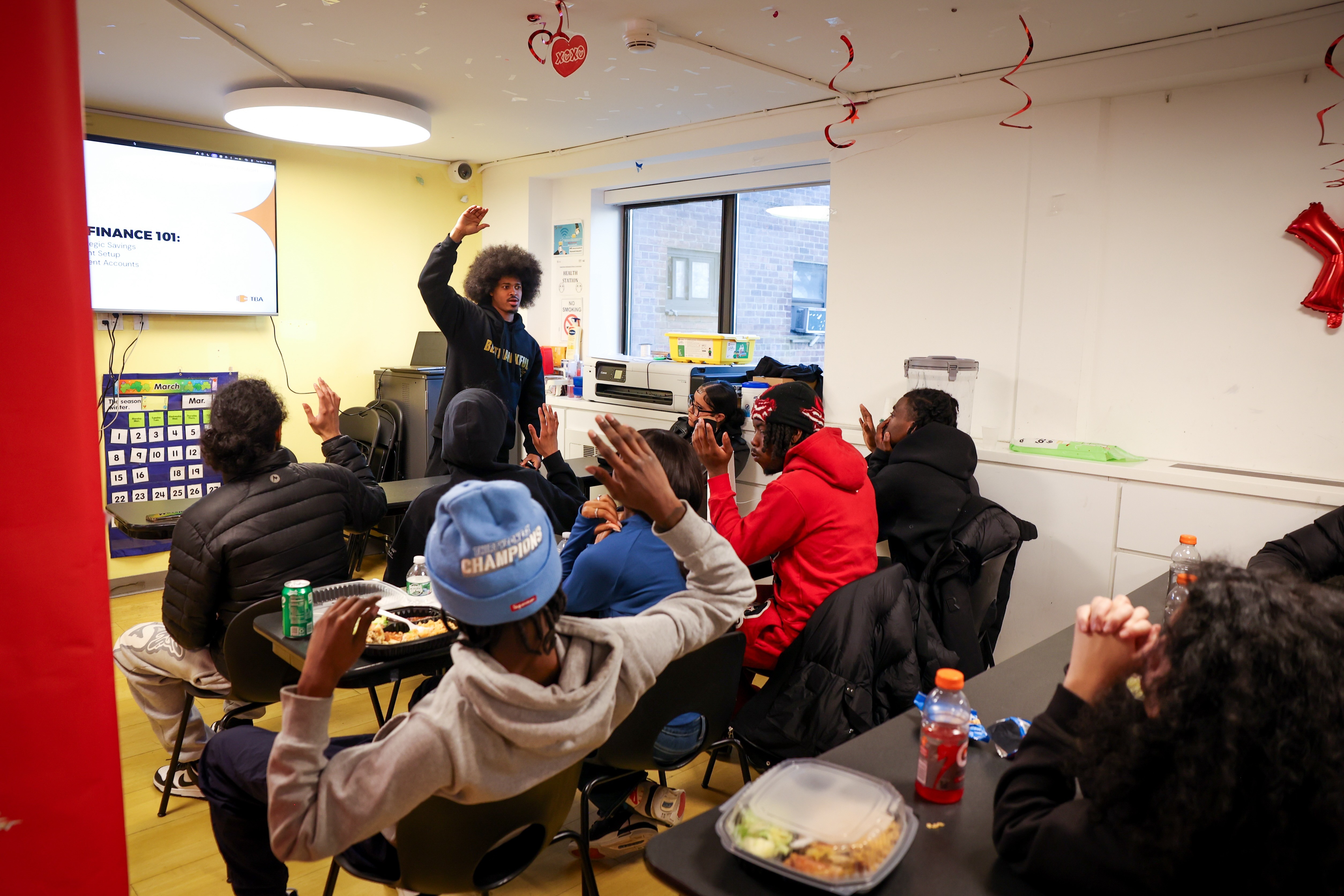Attendees of a finance 101 session raise their hands.