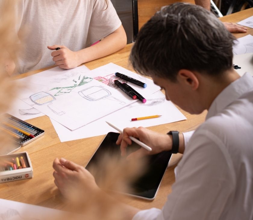 Designer sketching a custom illustrated resort map by hand, planning trails, terrain, and layout details.