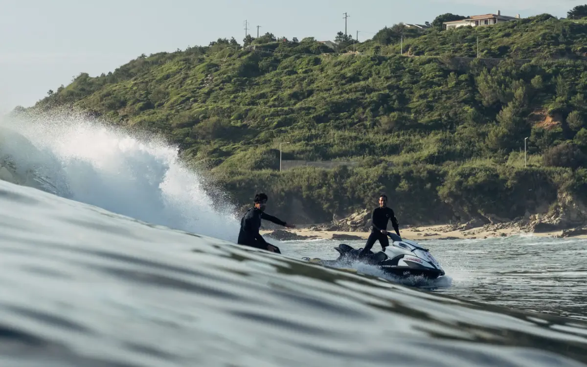 person surfing and a jet ski operator