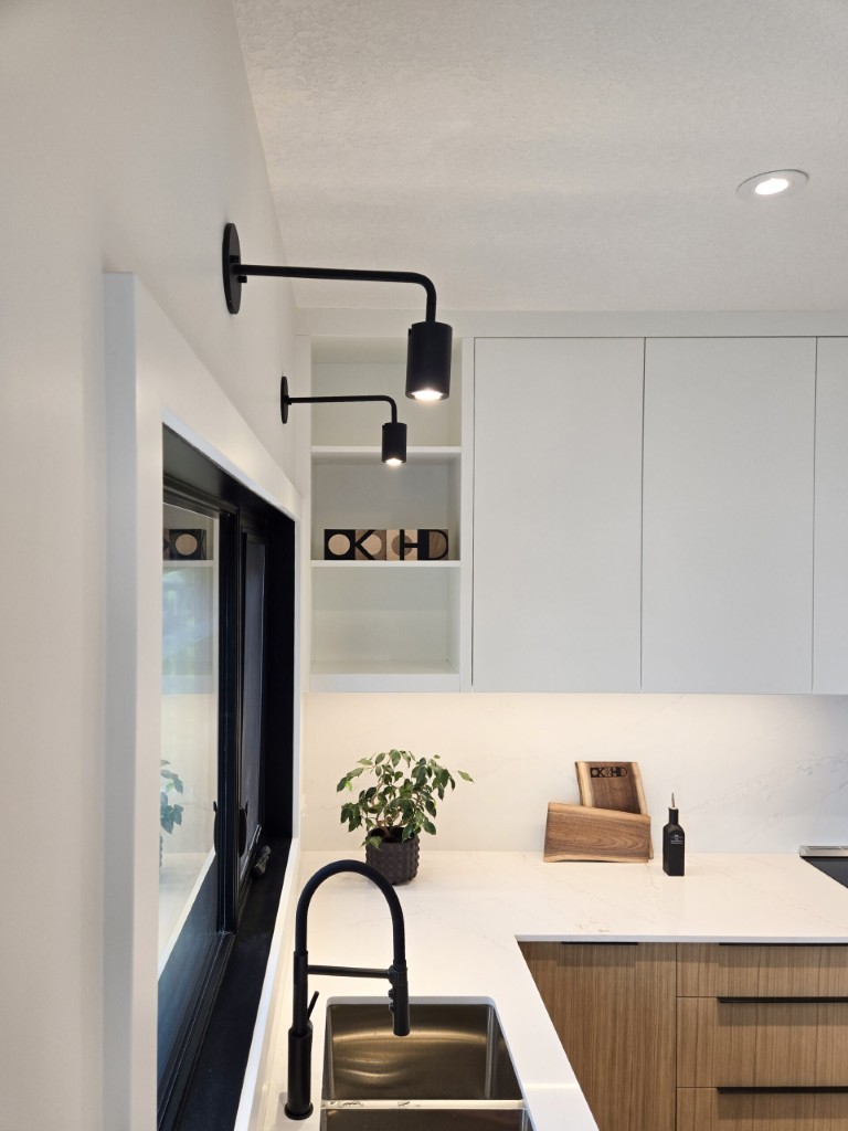 Image of "KHD Homes kitchen design with modern sink, black faucet, and sleek lighting fixtures, white countertops."