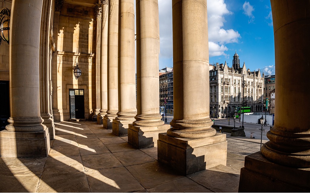 Stone colonnade of a historic civic building overlooking a British city, reflecting independence, formality, and fiduciary oversight in trust administration.