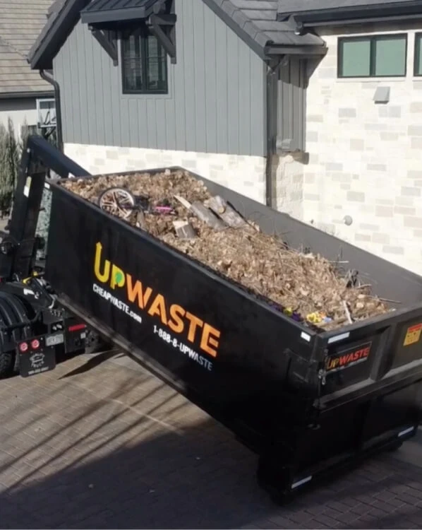Truck unloading sand from dumpster
