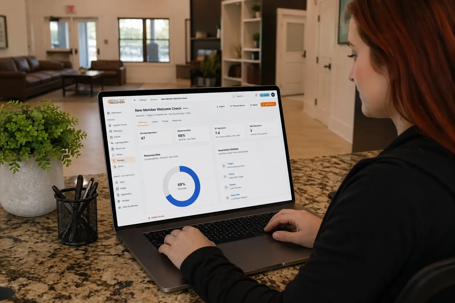 Clinician or treatment admissions looking at a Pathroot analytics dashboard on a laptop at the front desk