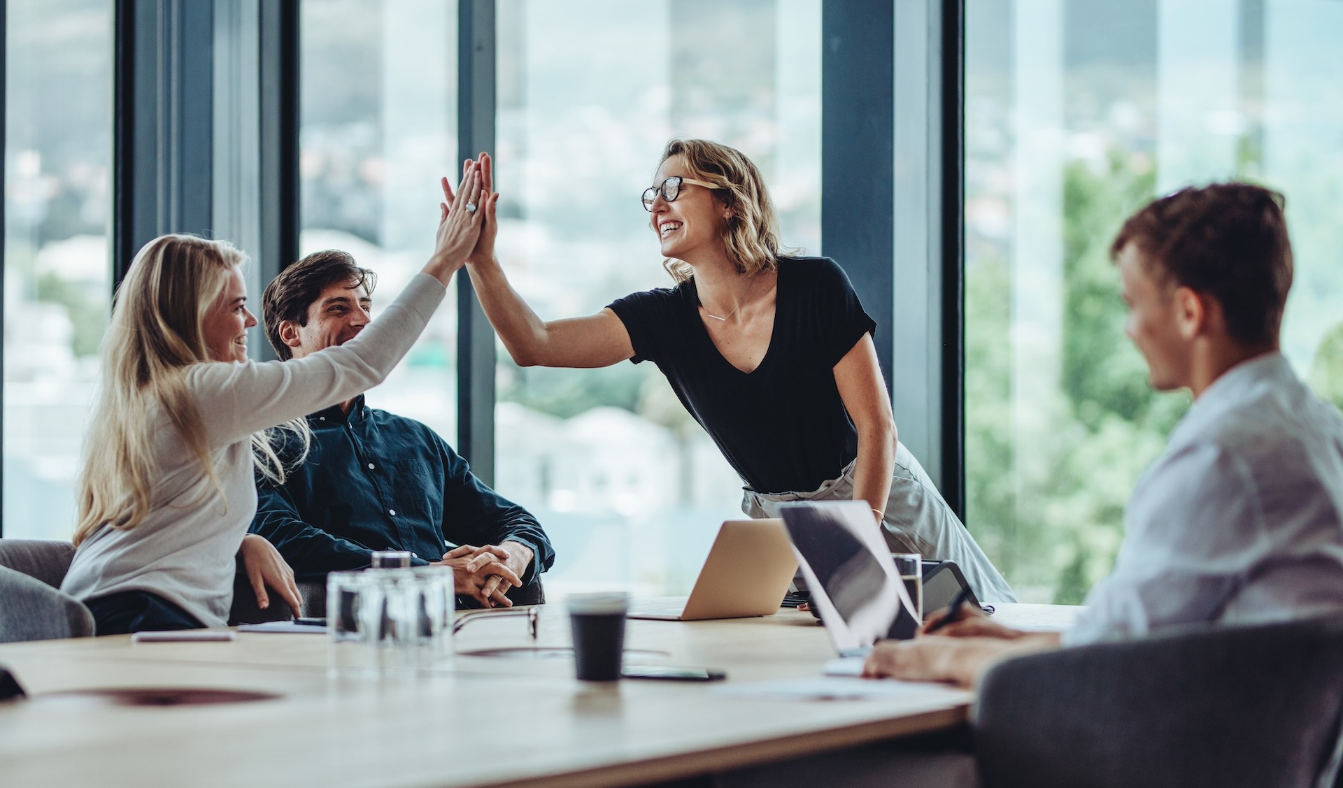 Zwei Büroangestellte geben sich einen High Five.