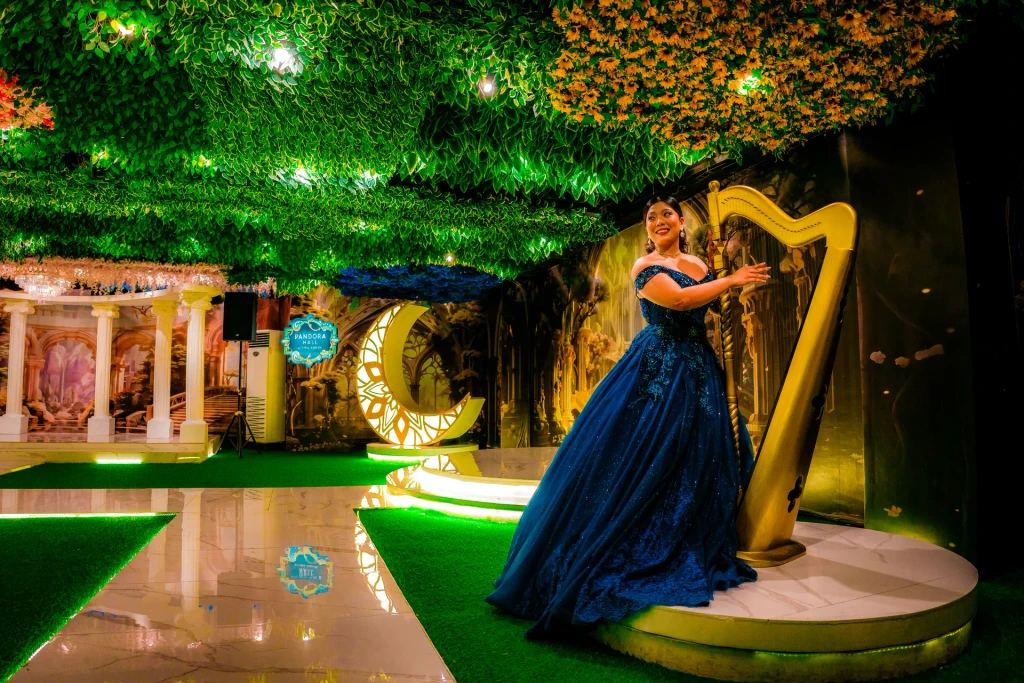 Debutante in a navy gown playing the harp at Pandora Hall, Quezon City