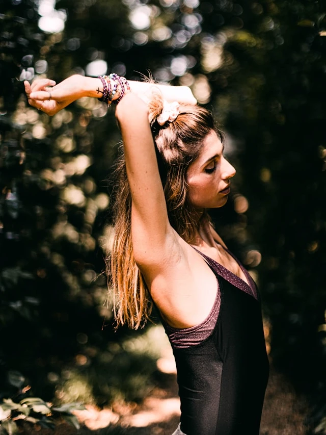 Woman sitting in an open field at golden hour
