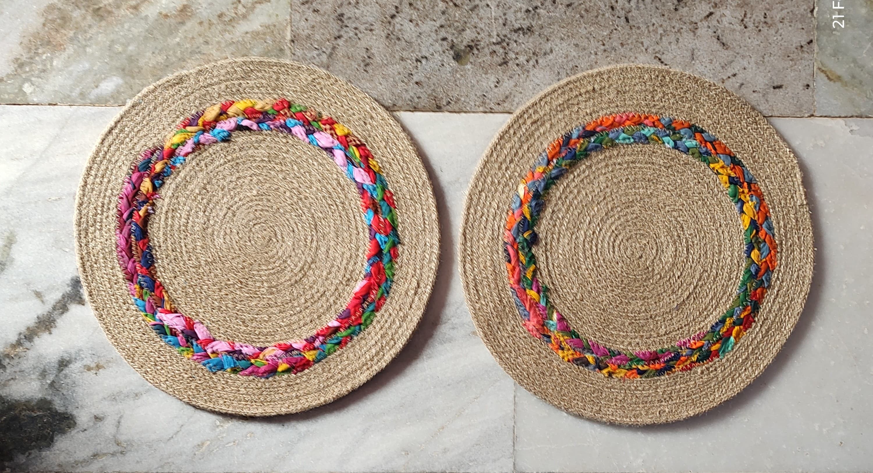 Handwoven round jute rug with multicolor braided border