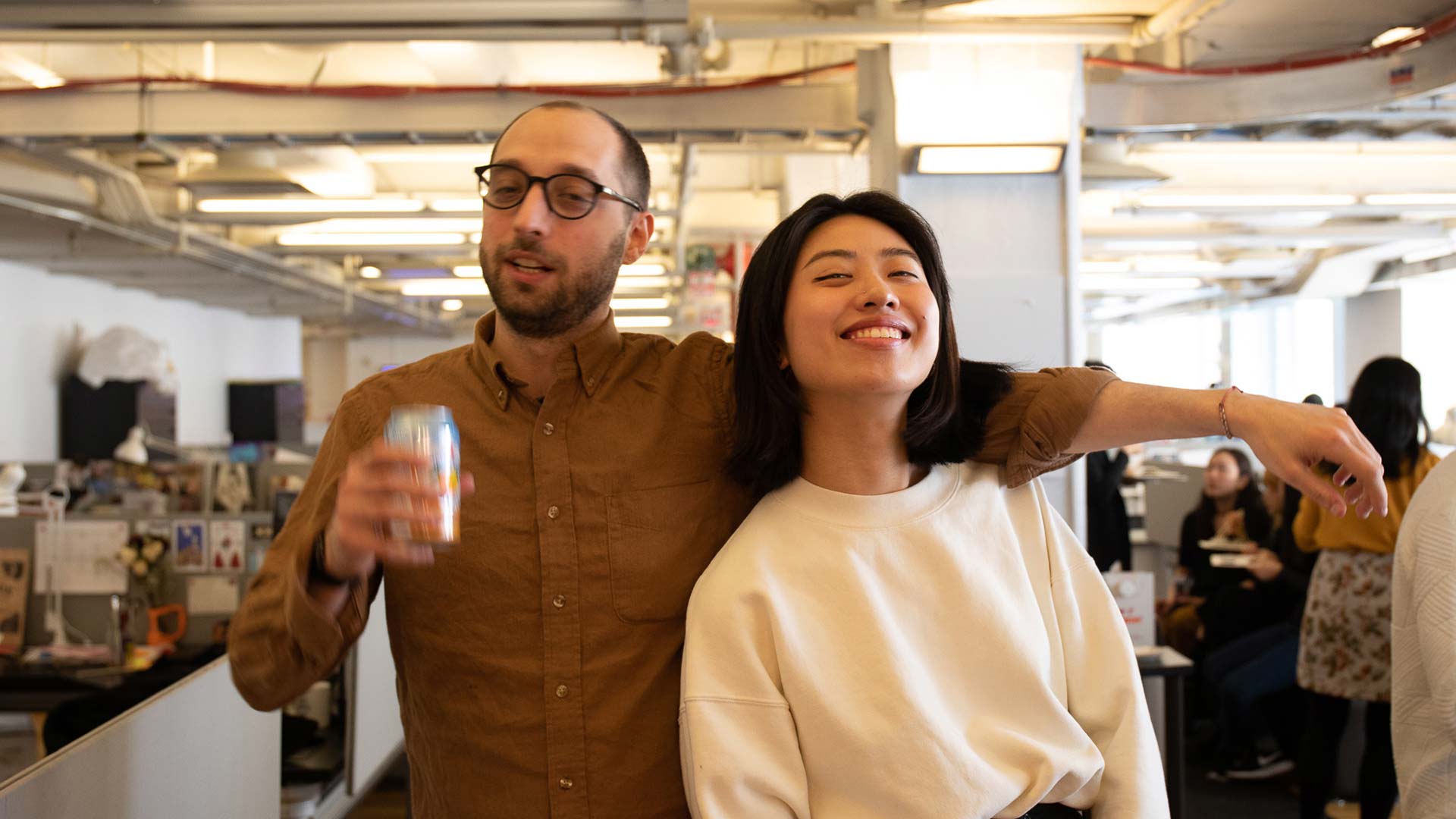 two students posing while holding sparkling water