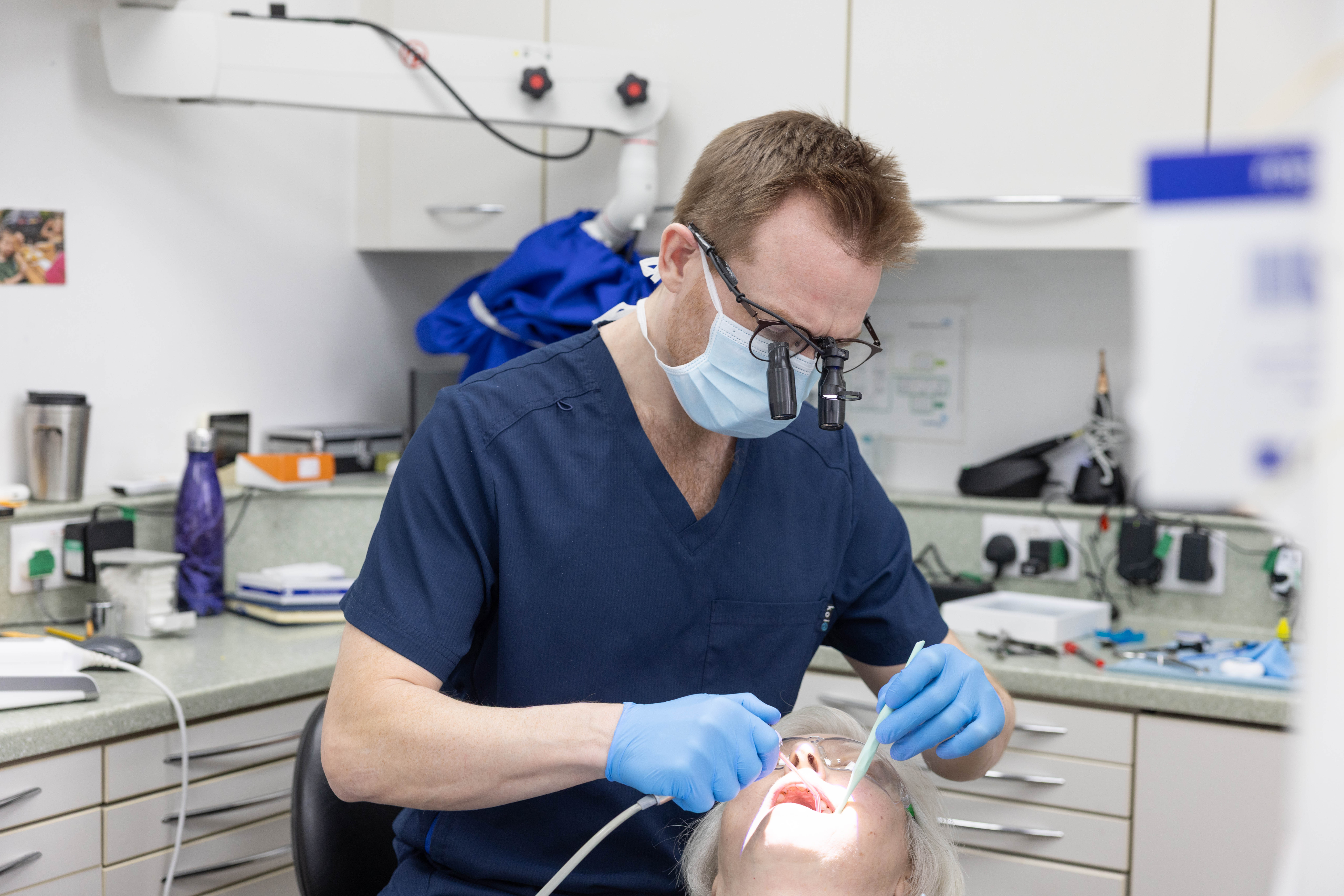 woman in white scrub suit holding white and green hose