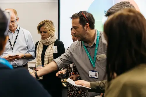 People standing and talking in a meeting room.