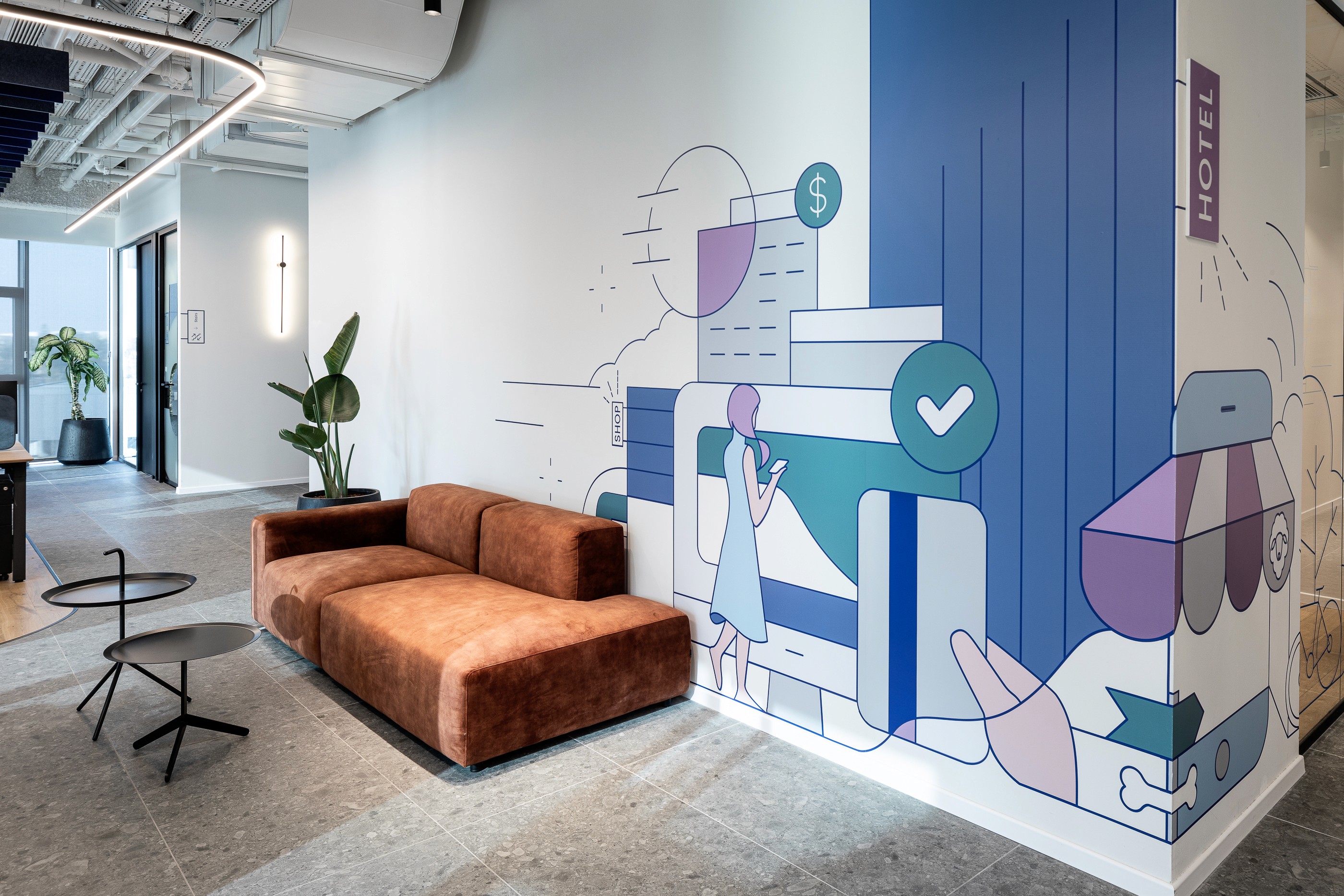 תכנון מעברים: מסדרון המשרד כציר מקשר, עם קיר גרפי מצד אחד ומחיצות זכוכית שקופות מצד שני לשמירה על קשר עין וזרימה בחלל.