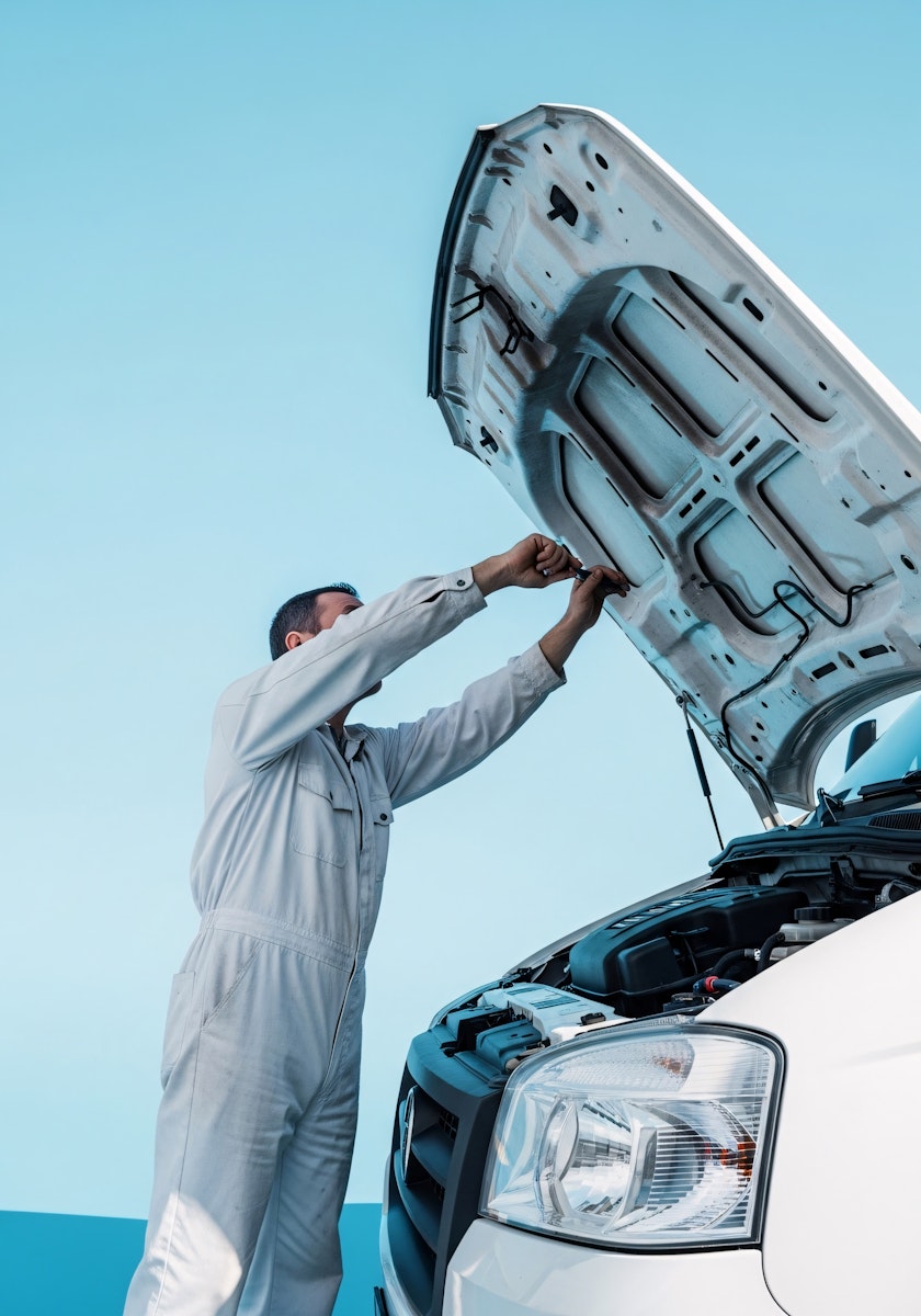 A couple of men standing next to a white car