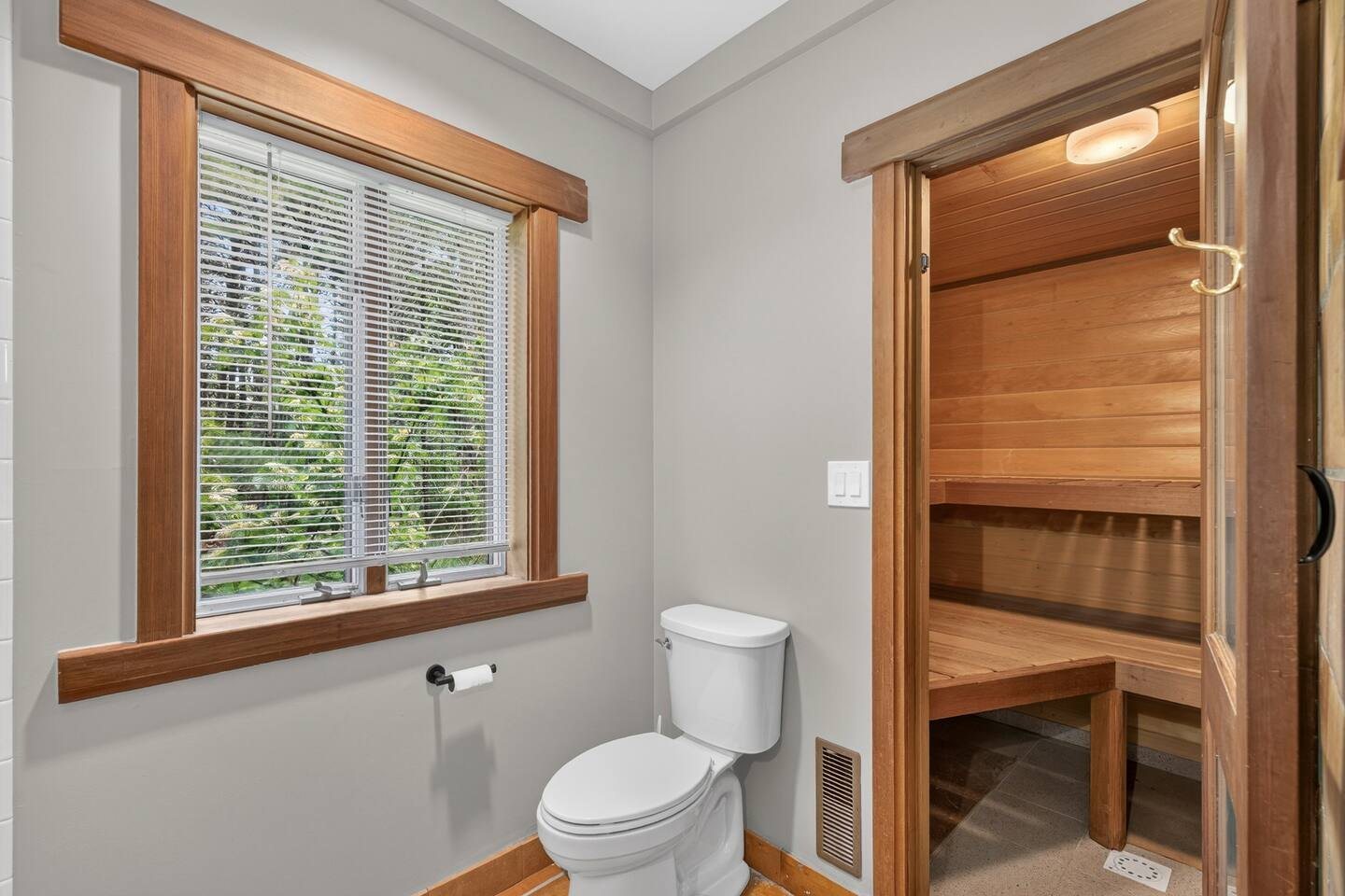 Bathroom with a door into a cedar-lined sauna