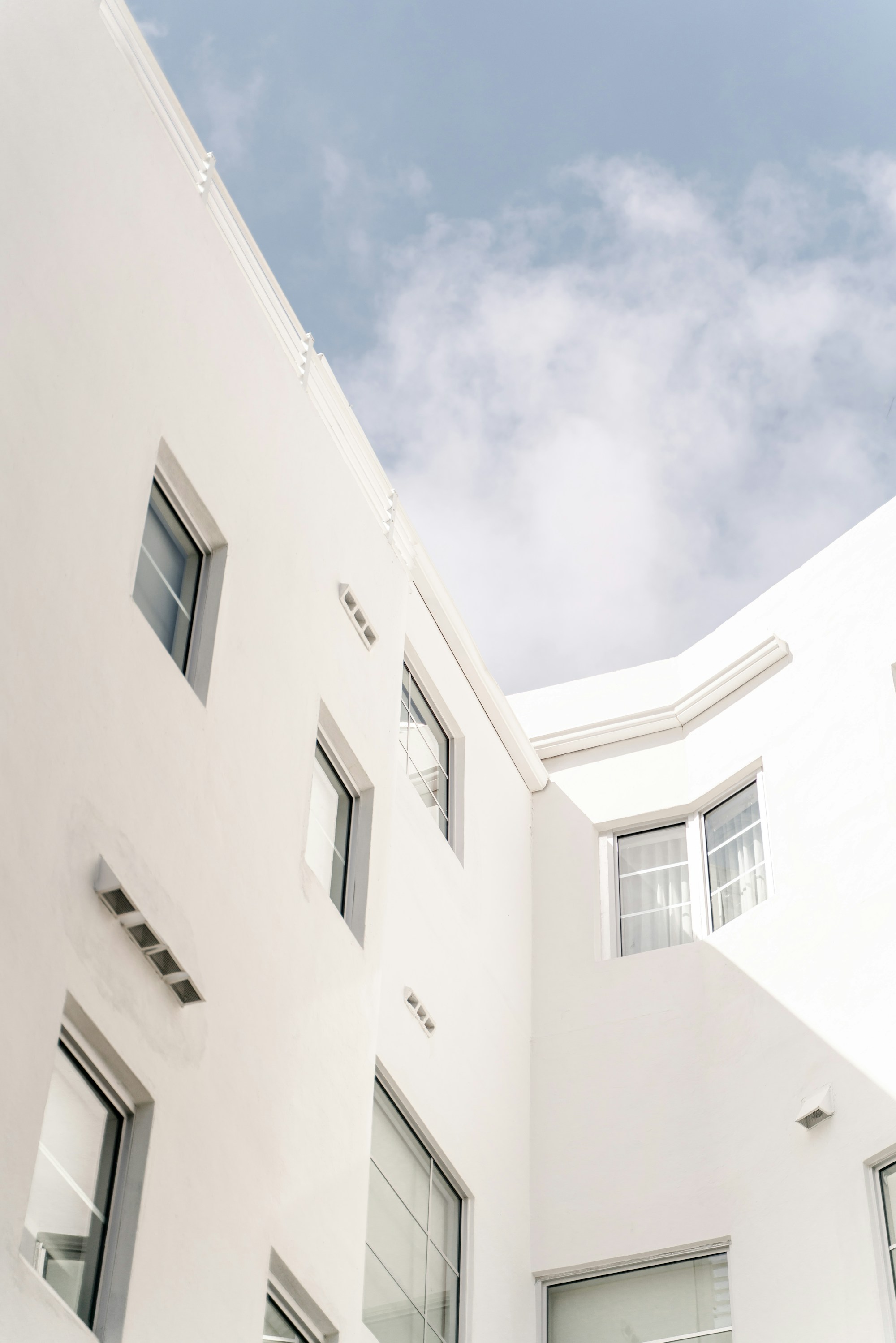 White architecture framing a quiet courtyard — atman studios / Unsplash