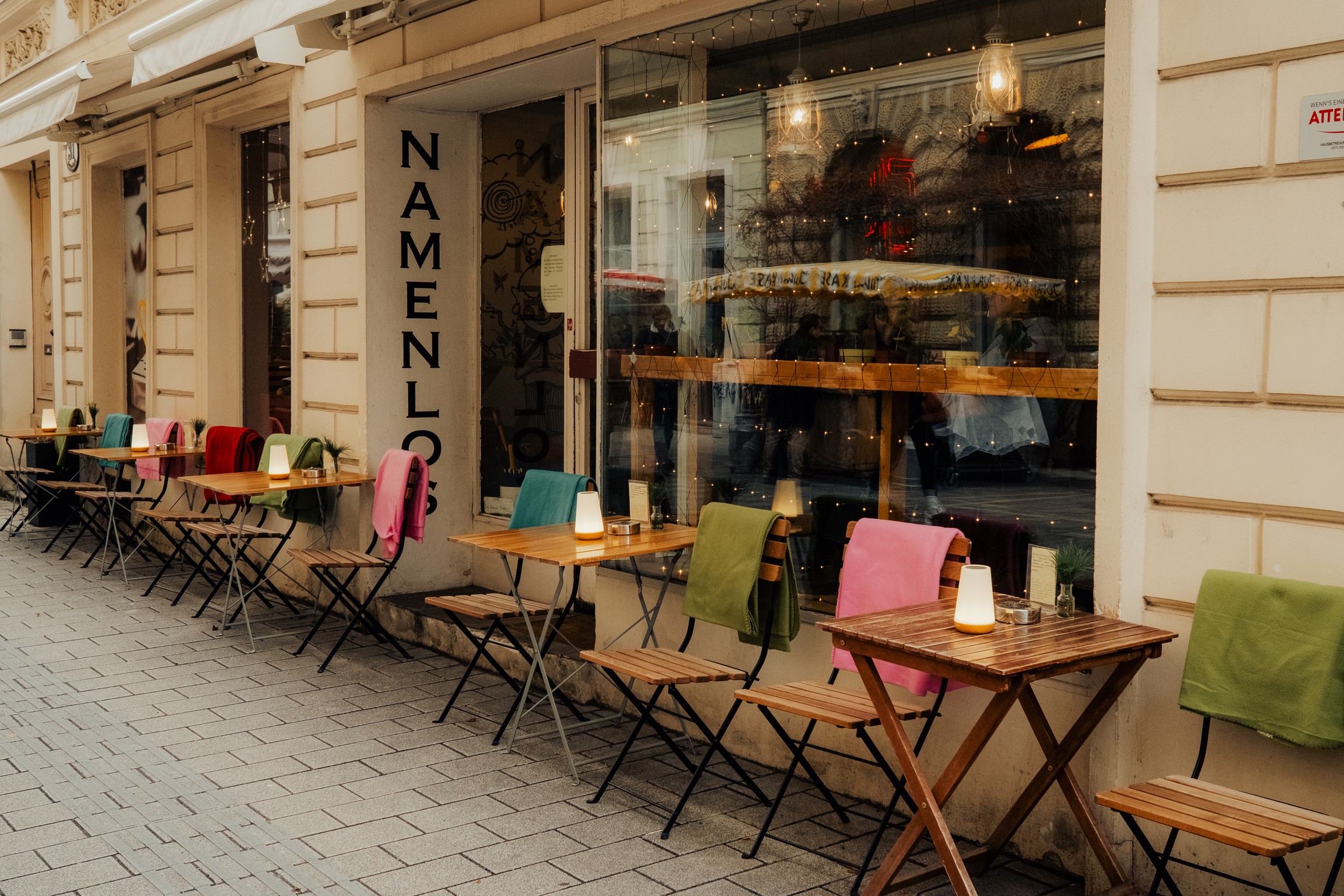 Terraza del café Namenlos con mantas de colores en las sillas