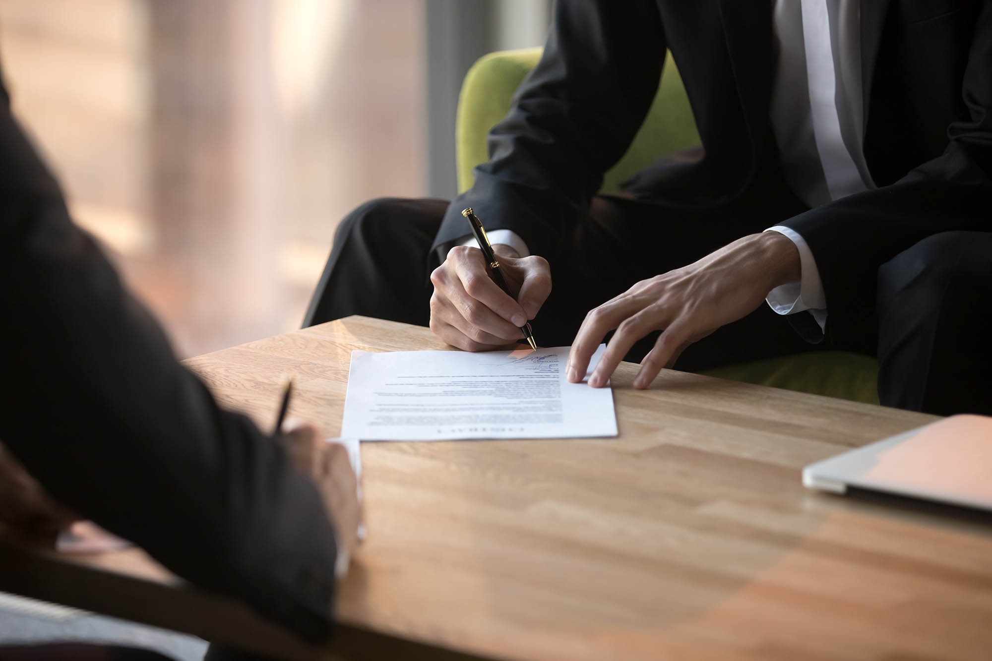 Businesswoman signing contract and discusses types of licenses in Dubai as part of Dubai economic department trade license renewal