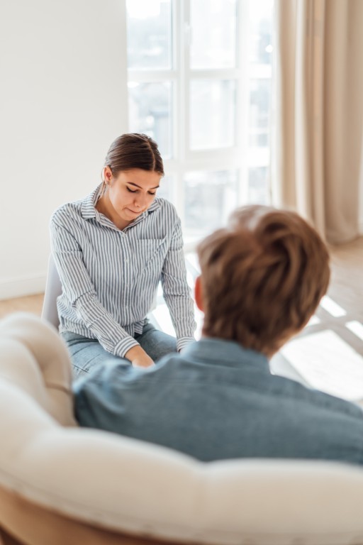 Mentor assisting a student with schoolwork, guiding him through explanations while both look at the mentor's work